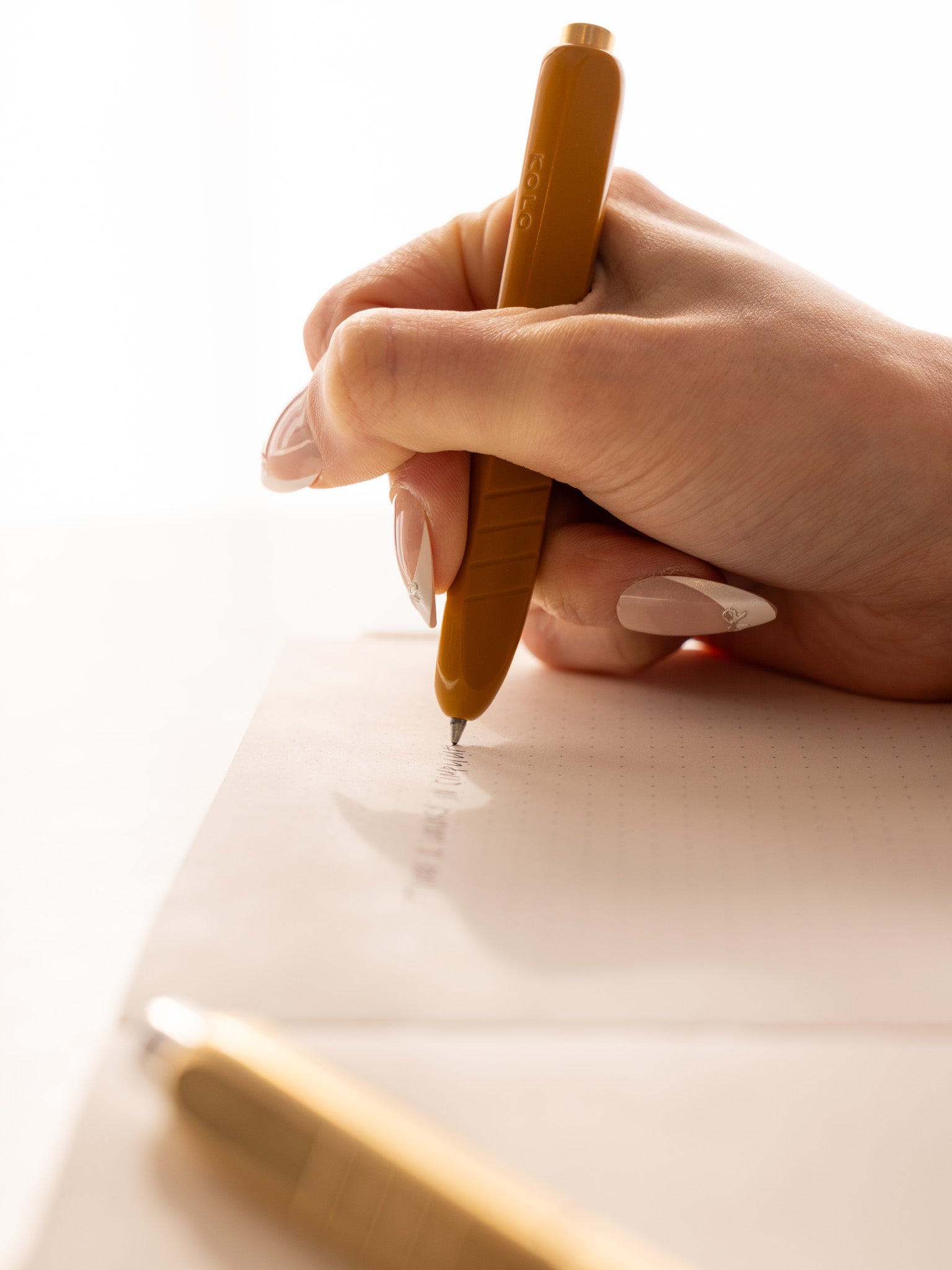 Hand writing with a Kolo Tino ballpoint pen in the color Acrylic Sunny.