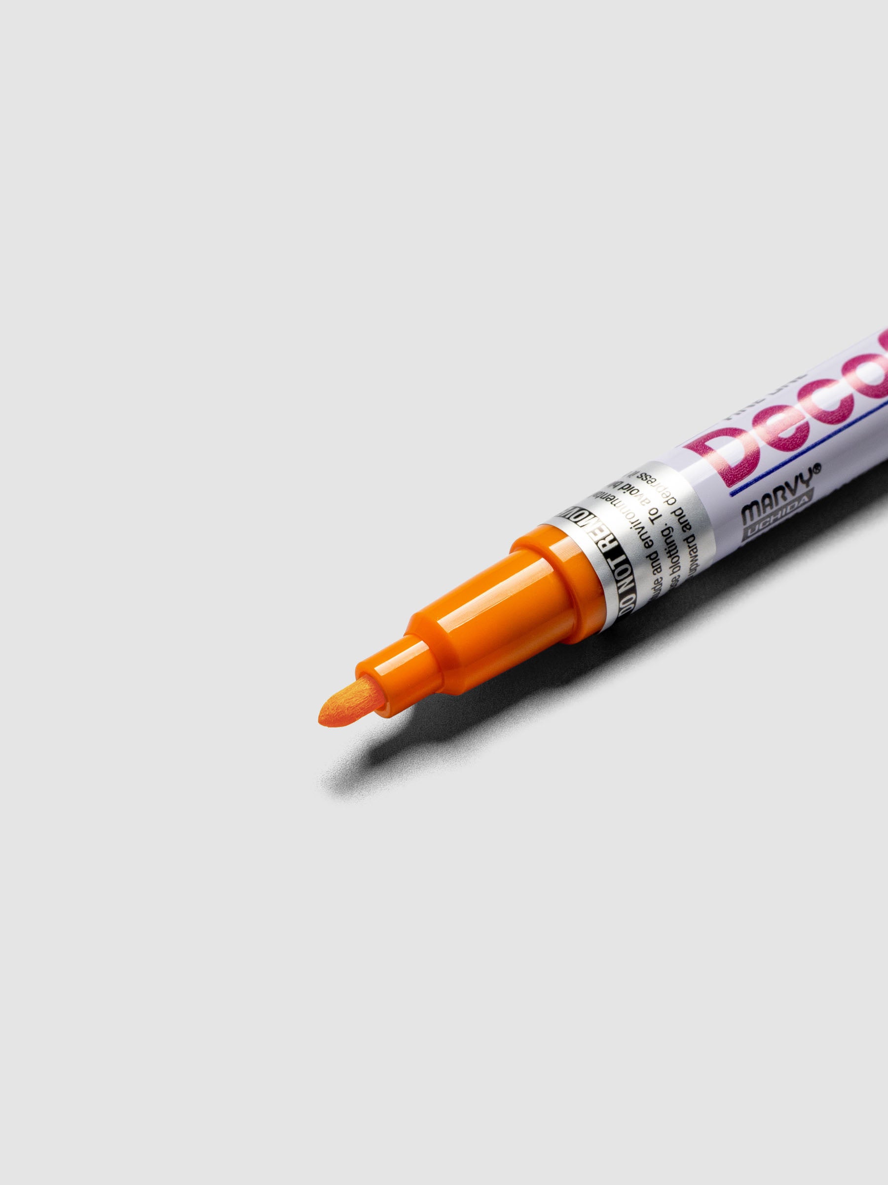 Close up of the Orange DecoColor paint marker in fine showing the nib