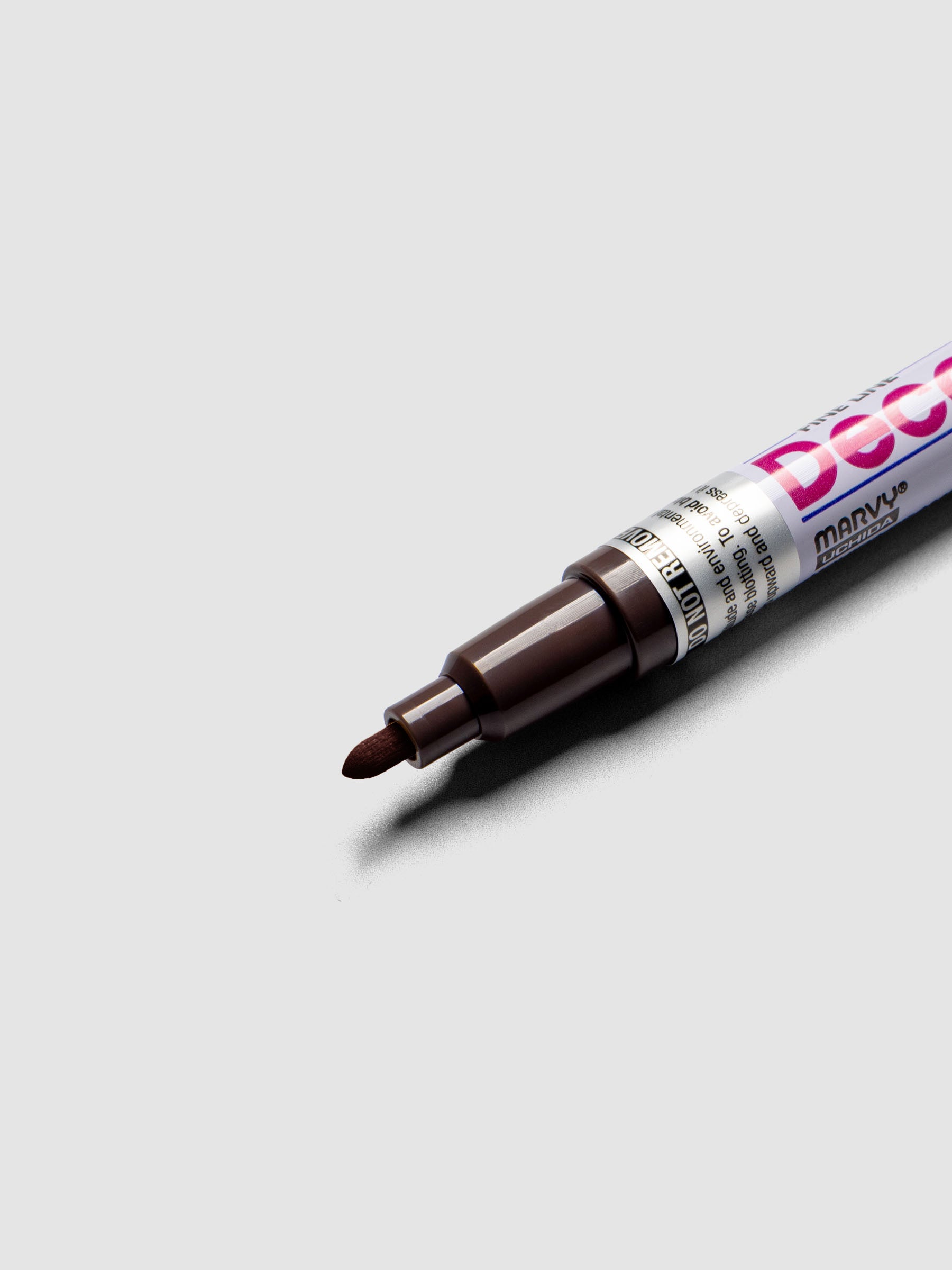 Close up of the Dark Brown DecoColor paint marker in fine showing the nib