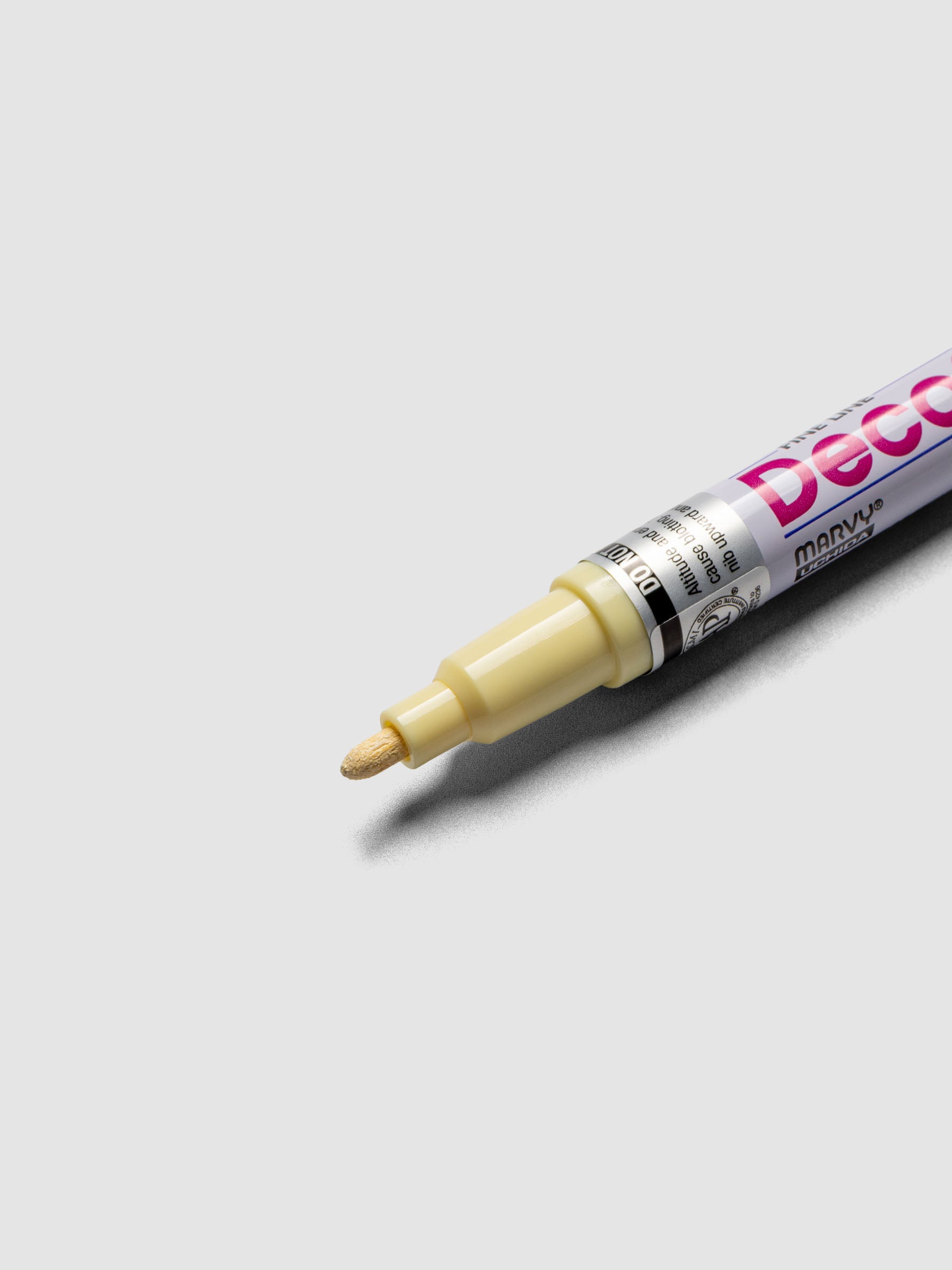 Close up of the Cream Yellow DecoColor paint marker in fine showing the nib
