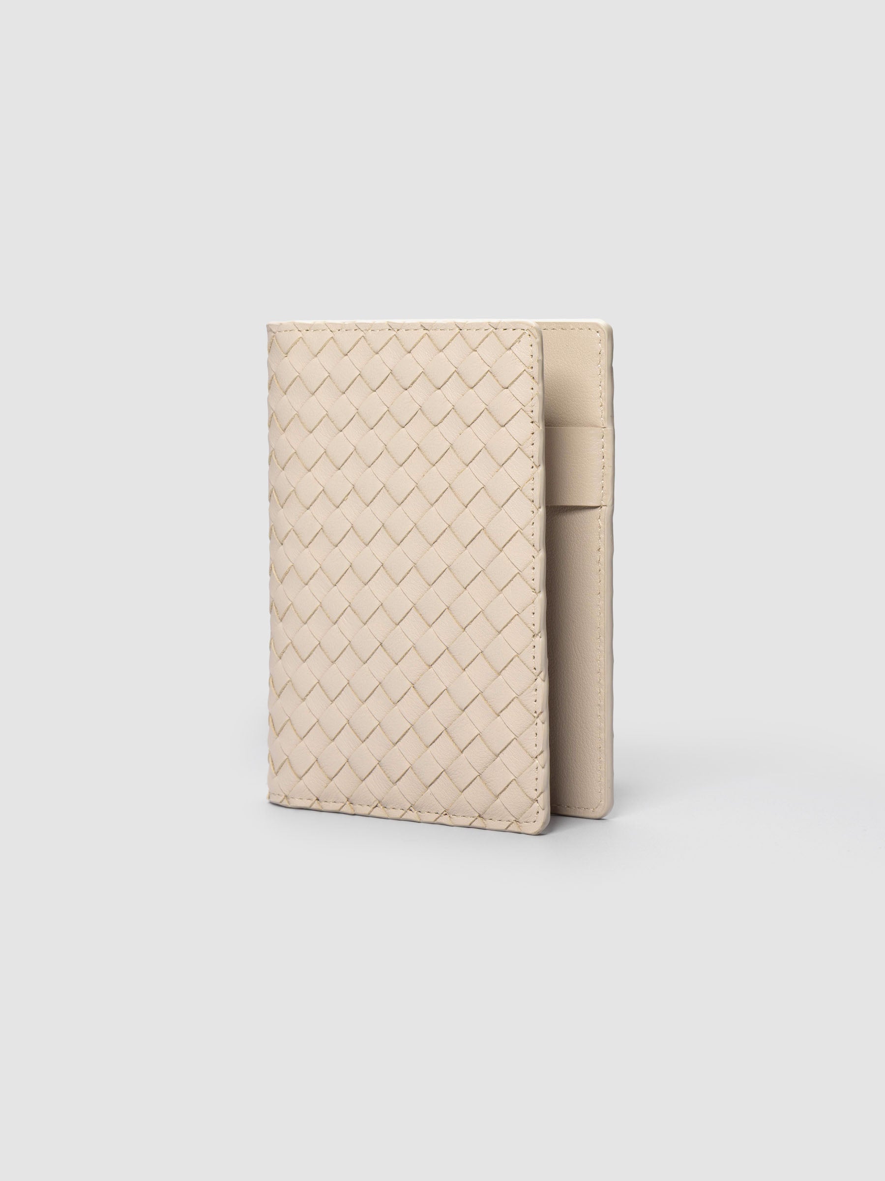 Beige woven leather planner cover shown standing at an angle.