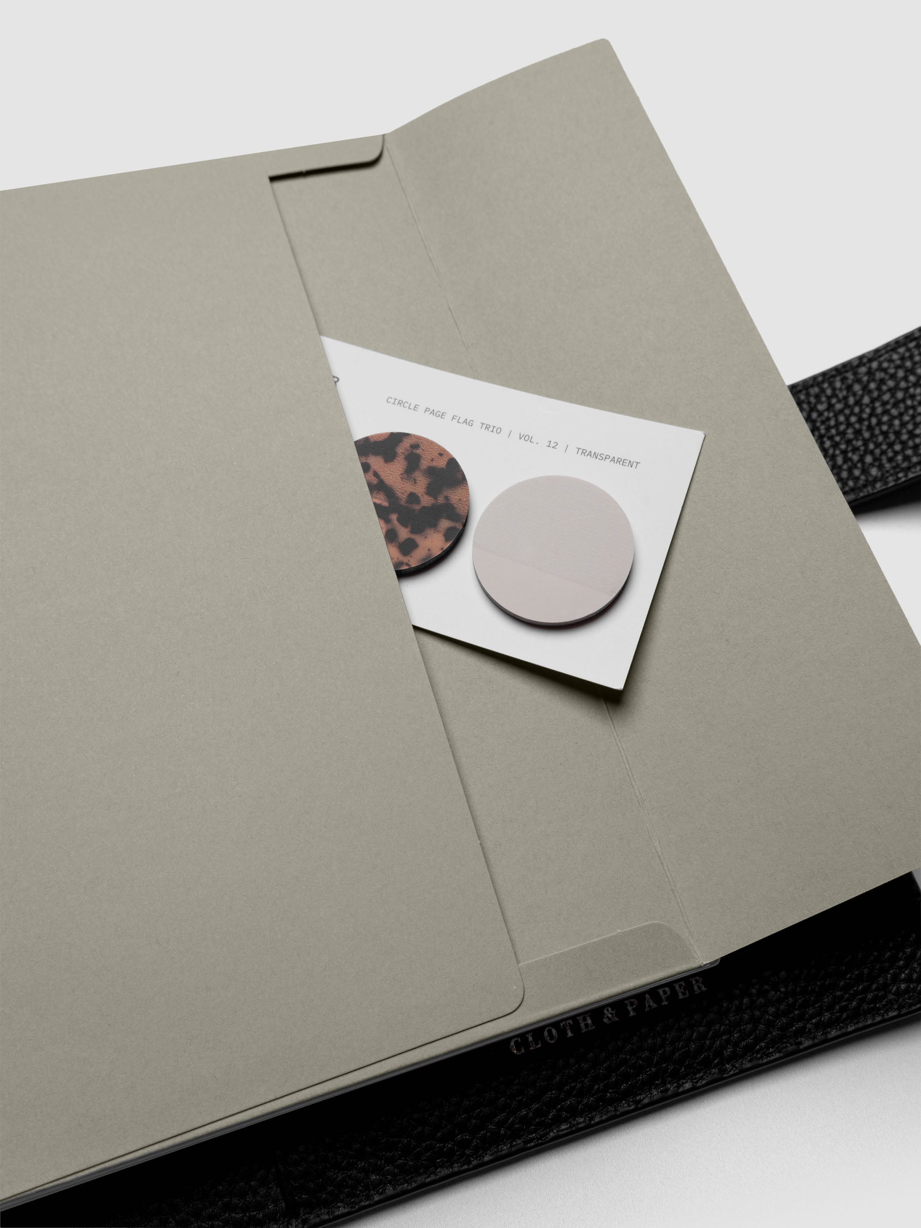 Beige Envelope Storage Holder shown inside a black, leather A5 agenda with page flags inside.