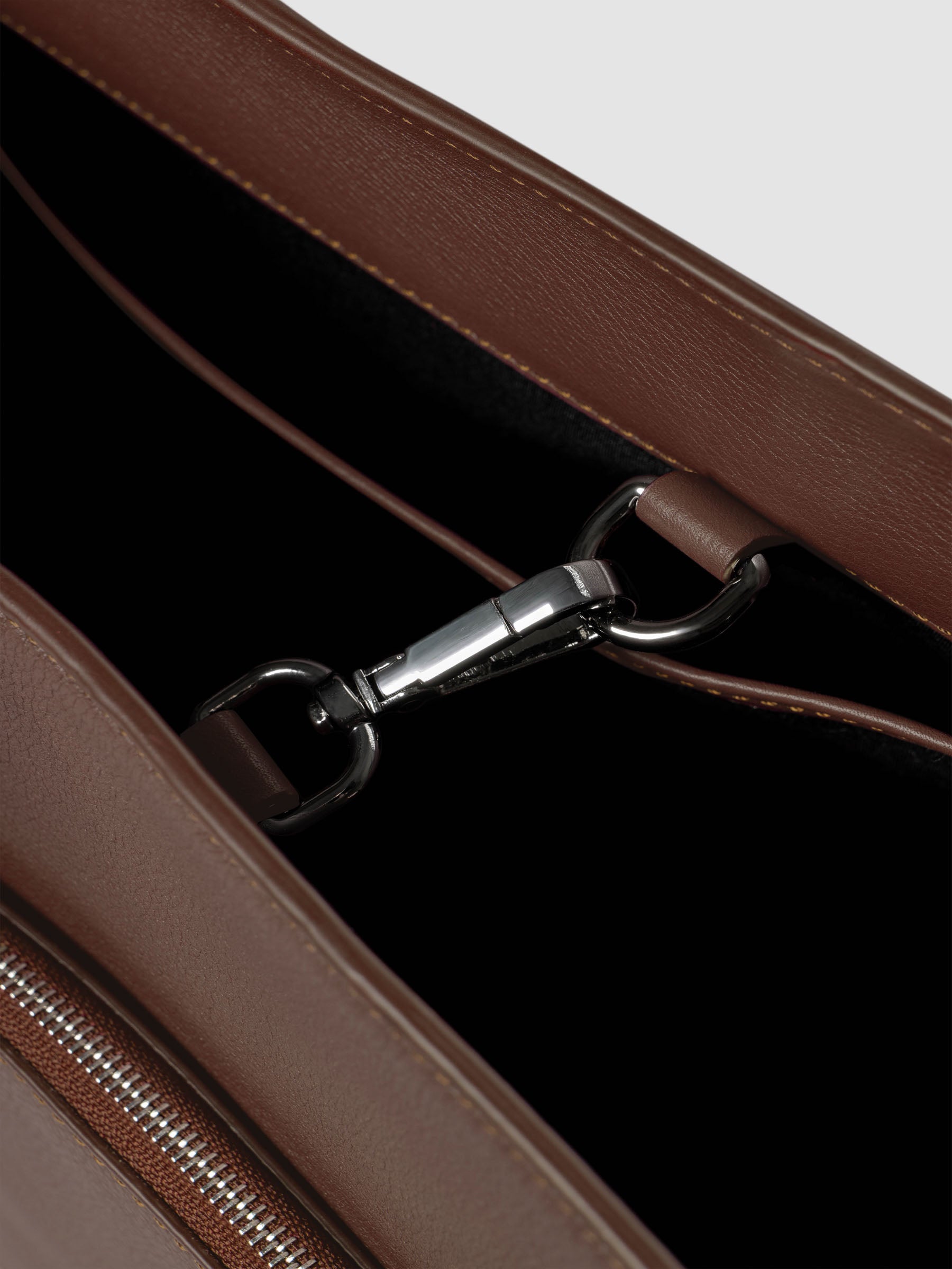 Detail view of the clip closure on The Metro Tote in the color Cordoba.