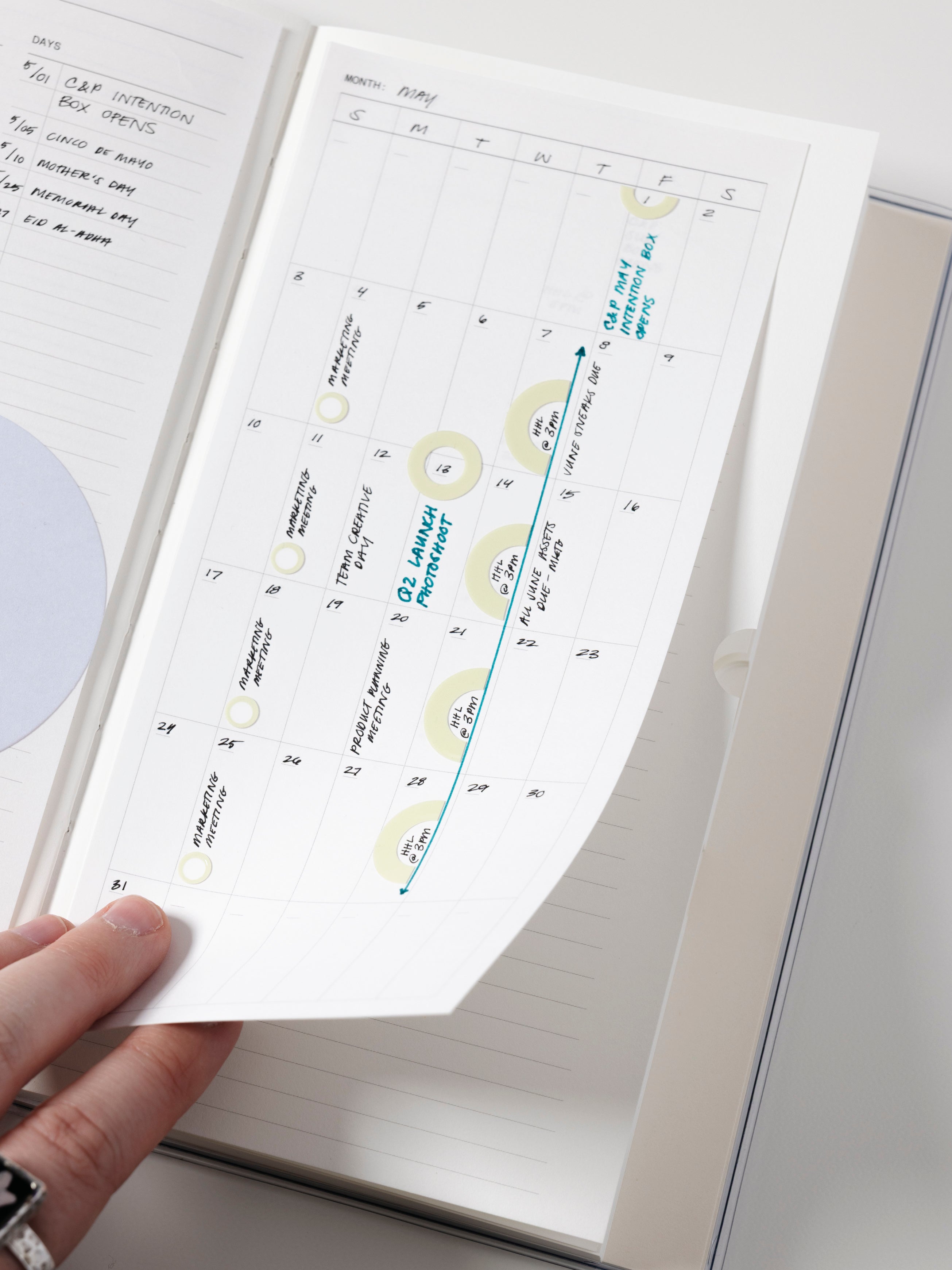 Monthly calendar sticky note in use in a notebook with handwritten planning notes