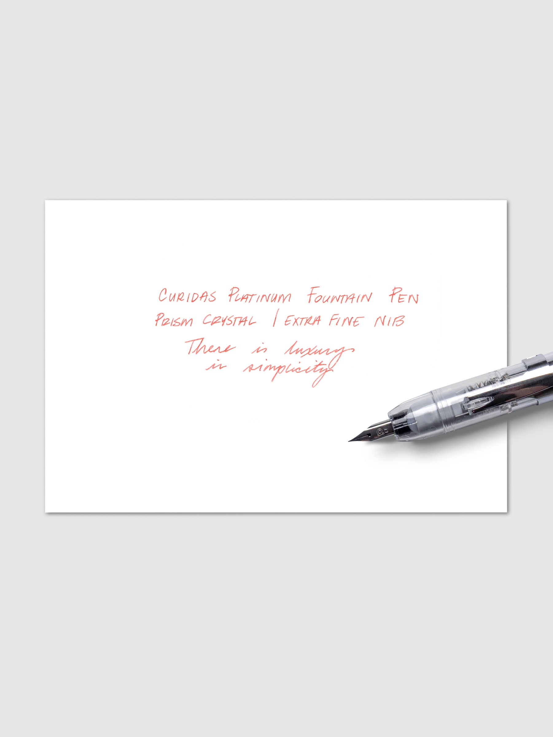 Writing sample with Platinum Curidas pen shown on a neutral background. Ink color is red.