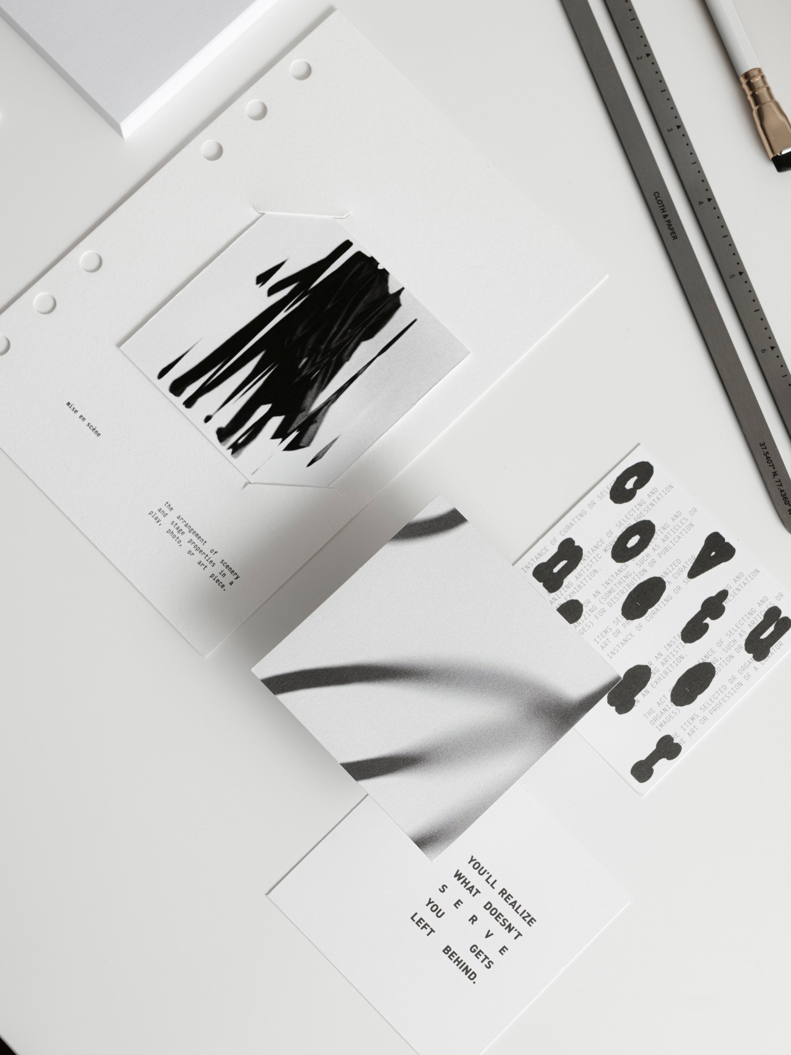 Mise en scène dashboard insert, journaling cards, and punched sticker sheet laid flat on a white surface alongside a stainless steel ruler and black pencil