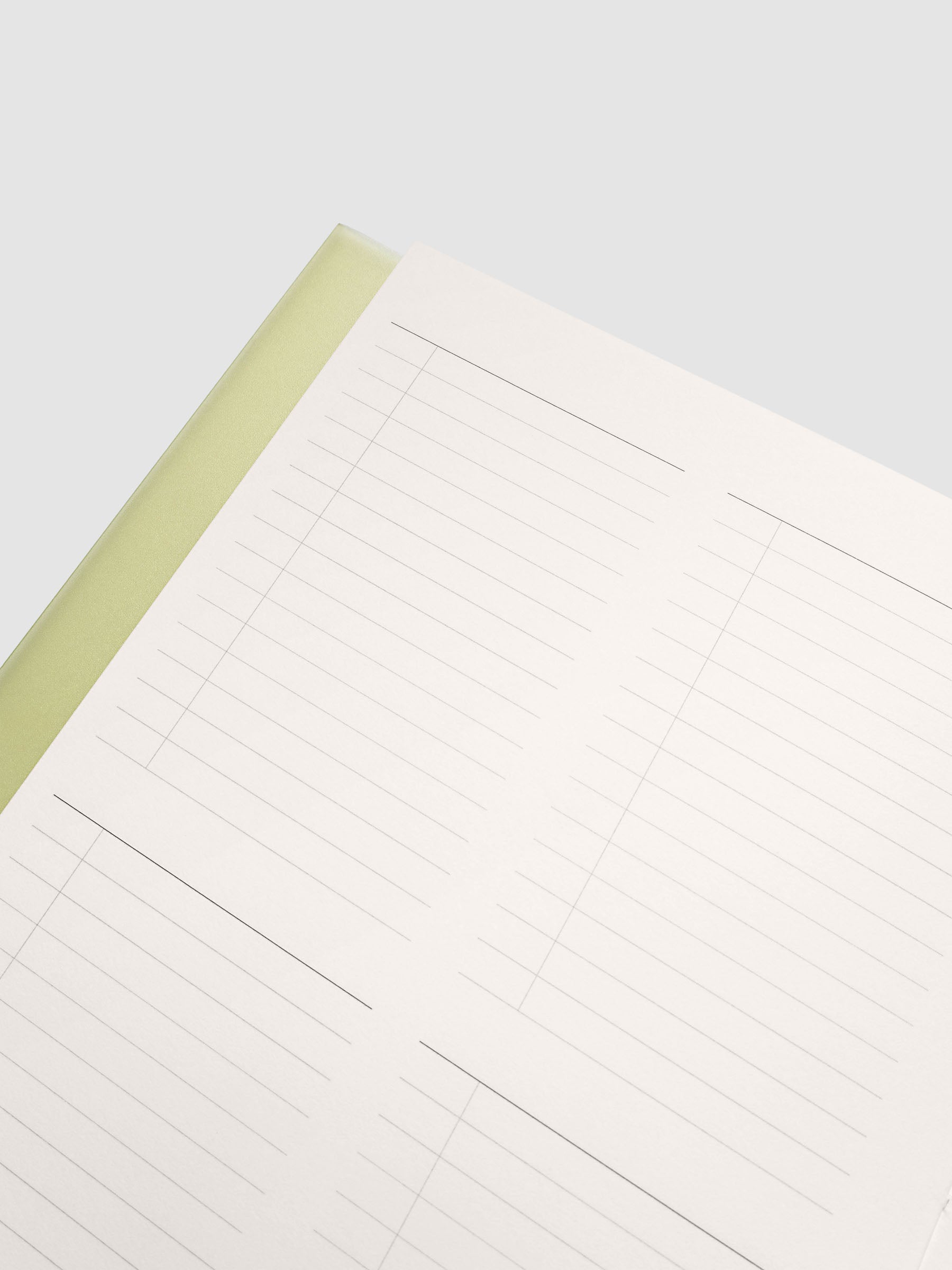 Close up of the Perfect Bound Notebook | A5 | Quad Checklist open at an angle, pale yellow spine edge beside a ruled checklist page