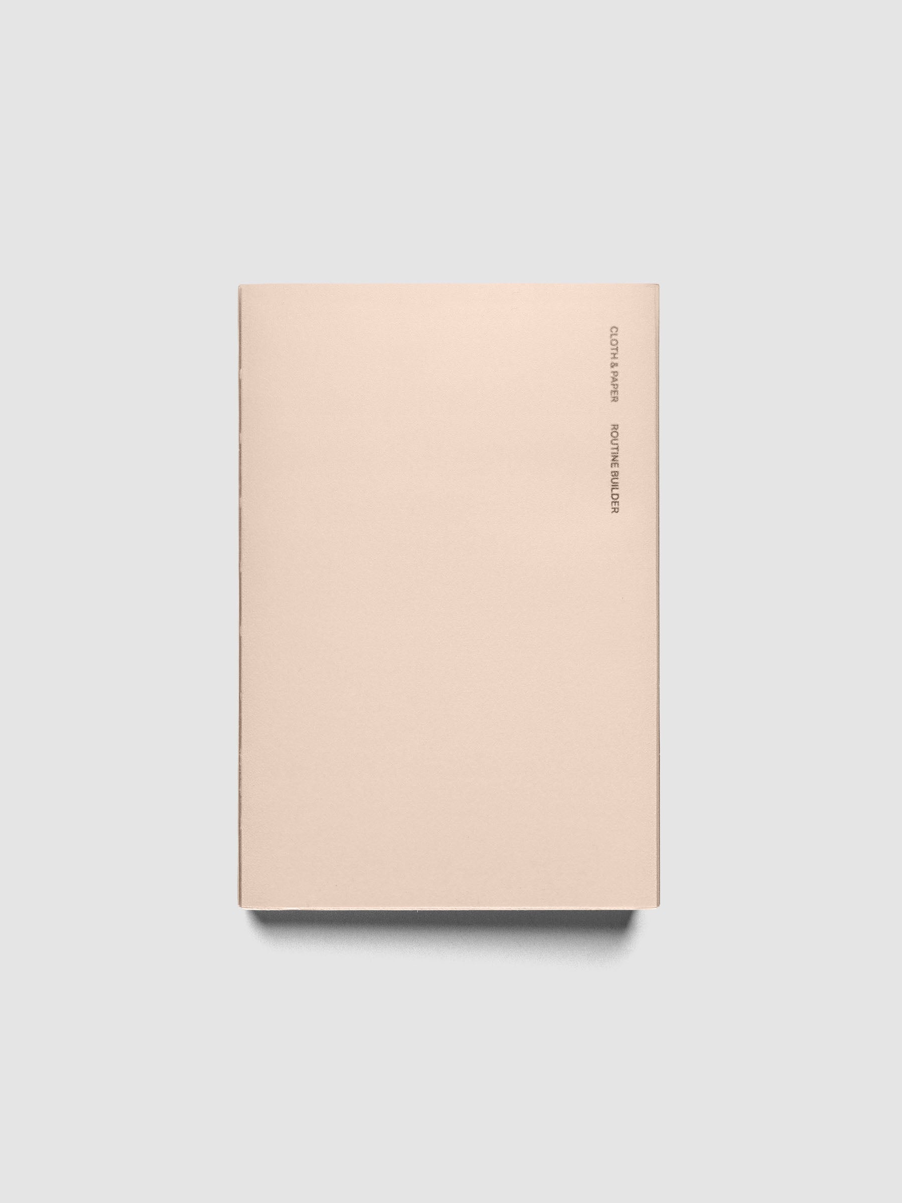 Perfect Bound Notebook | CP Petite | Routine Builder shown closed on a neutral background, plain blush cover