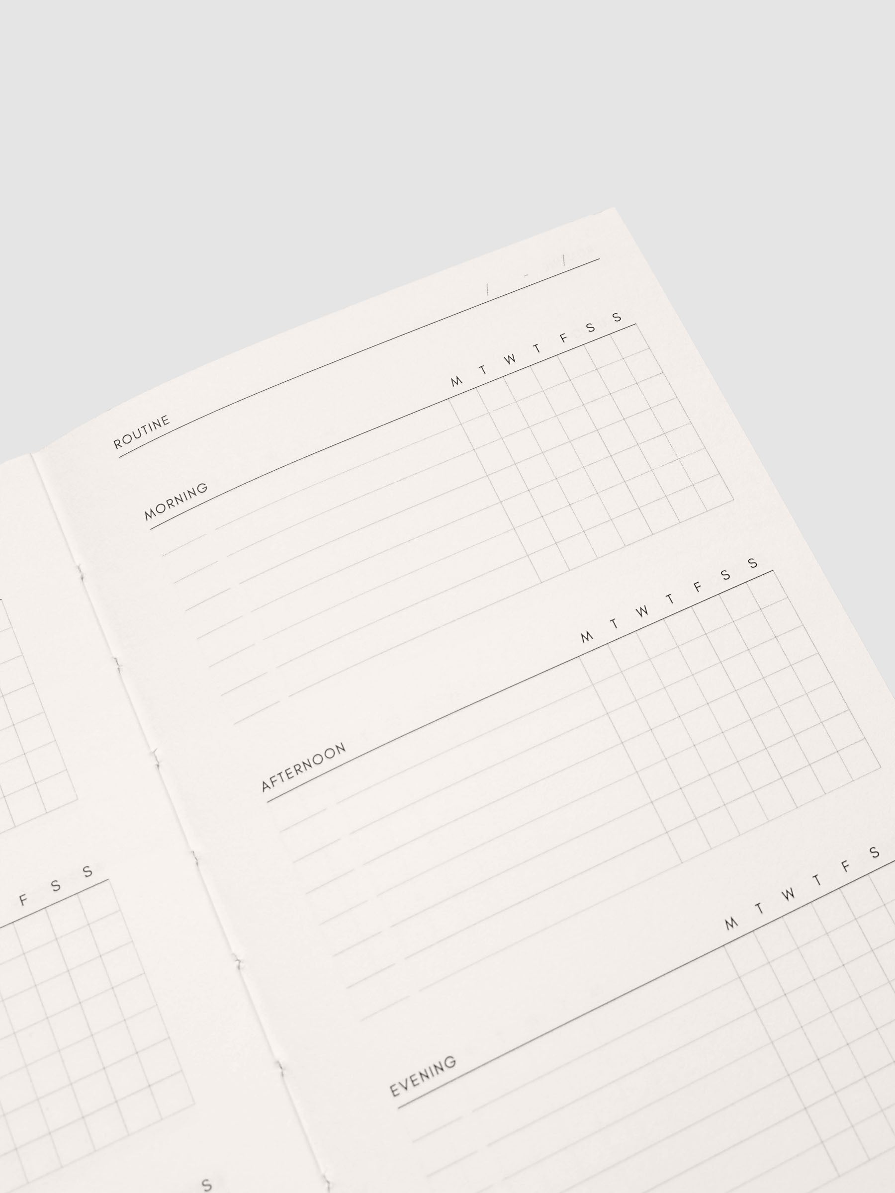 Close up of the Perfect Bound Notebook | CP Petite | Routine Builder pages at an angle, showing the routine tracking columns