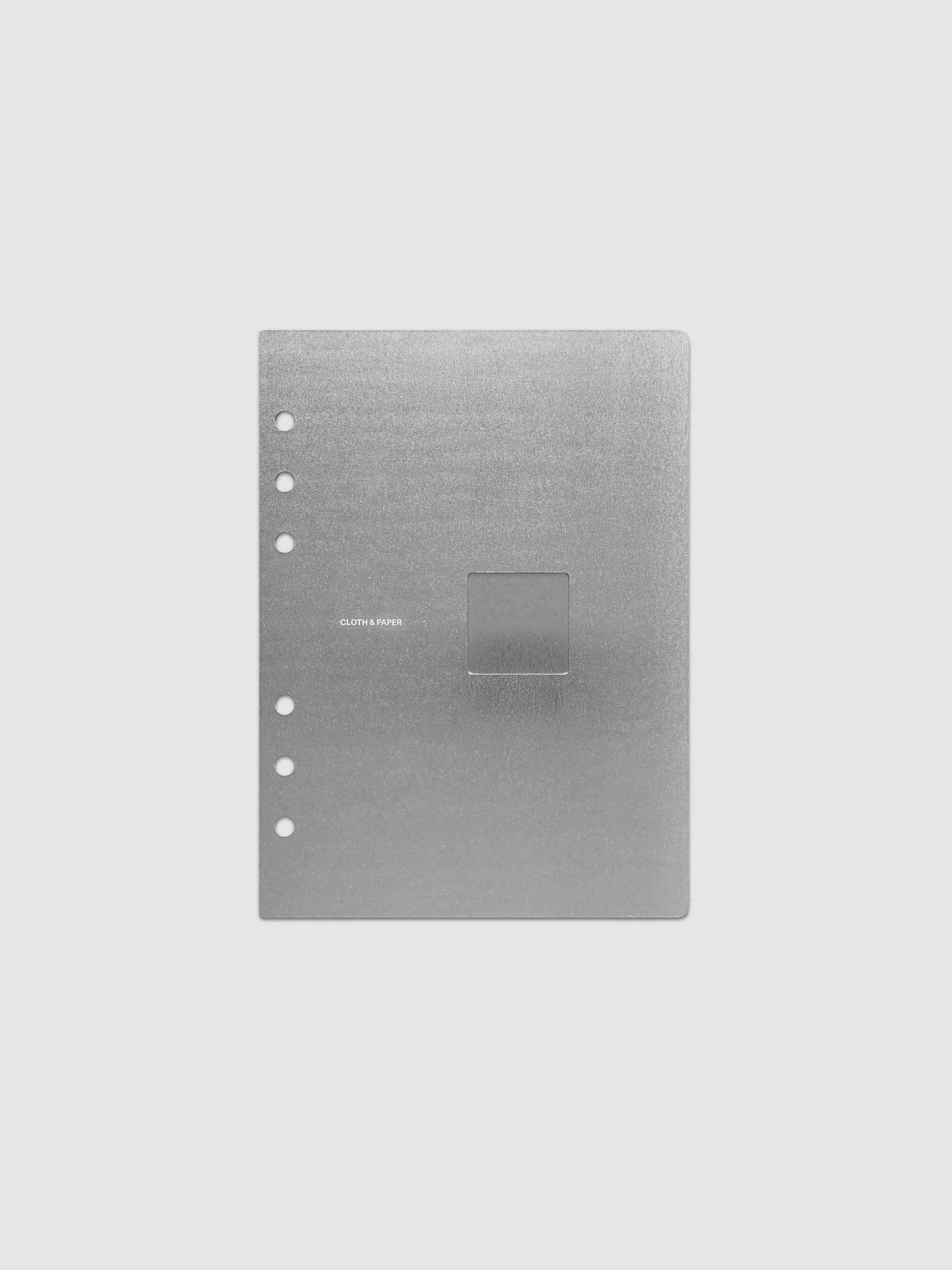 A brushed silver metal panel with a single rectangular cutout in the center and six pre-drilled holes along the left edge, shown on a light gray background.