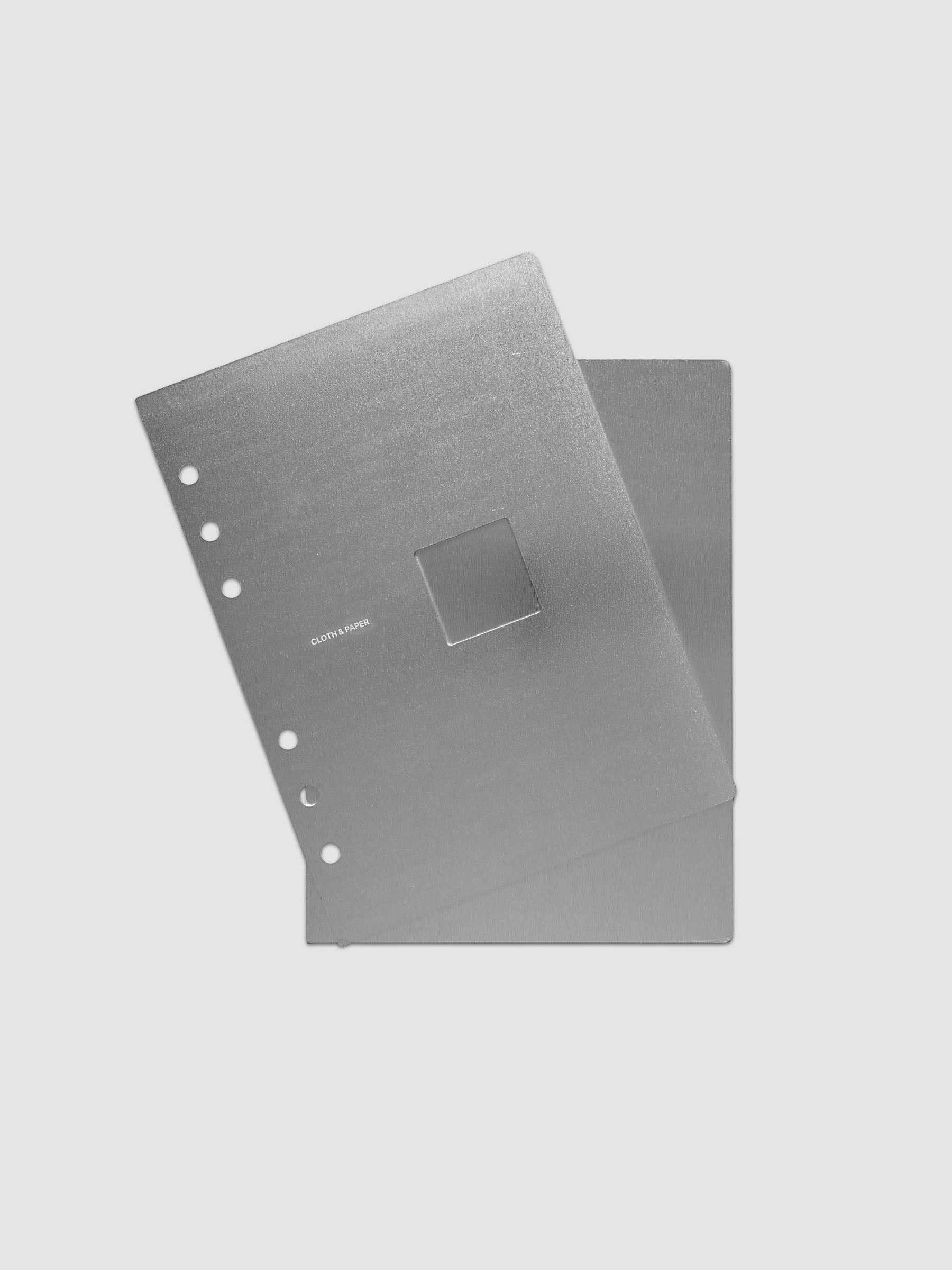 A brushed silver metal panel with a single rectangular cutout in the center and six pre-drilled holes along the left edge, shown on a light gray background.