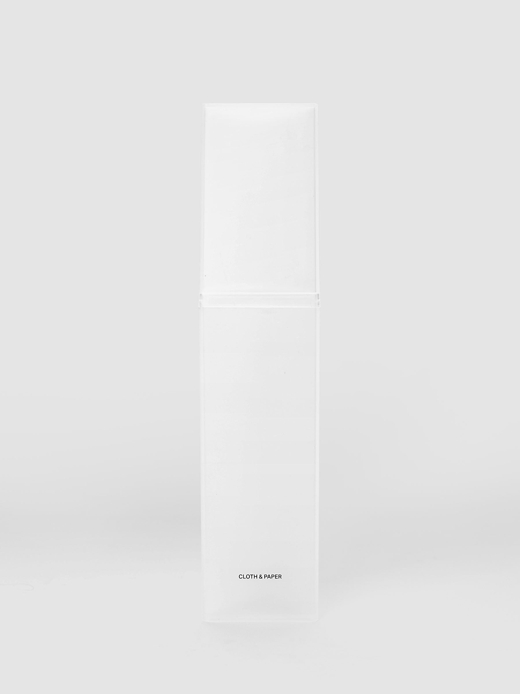 Pencil Box | Frosted, a triangular frosted plastic pencil case with a black logo on a light gray background