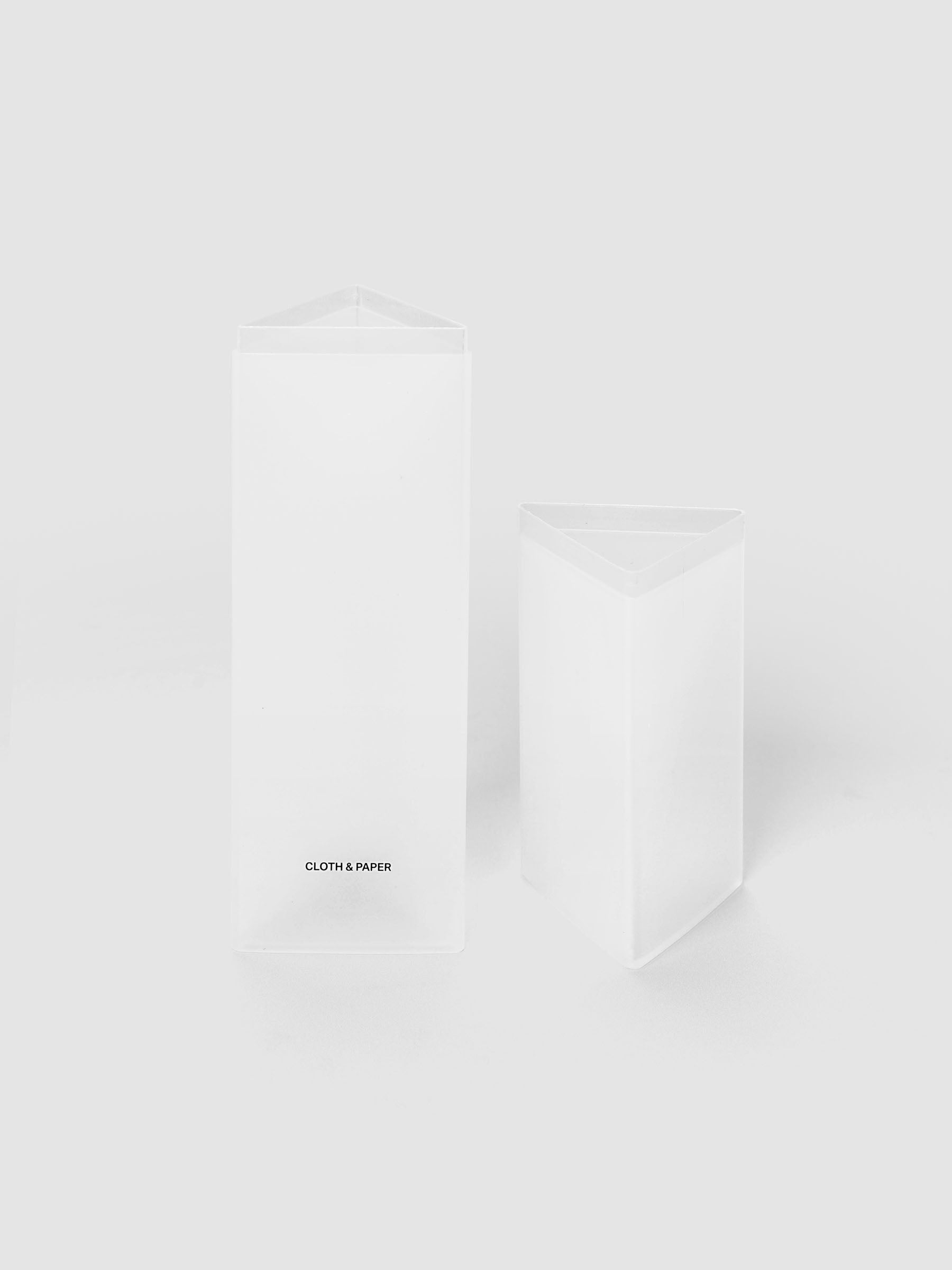 Pencil Box | Frosted, a triangular frosted plastic pencil case with a black logo on a light gray background