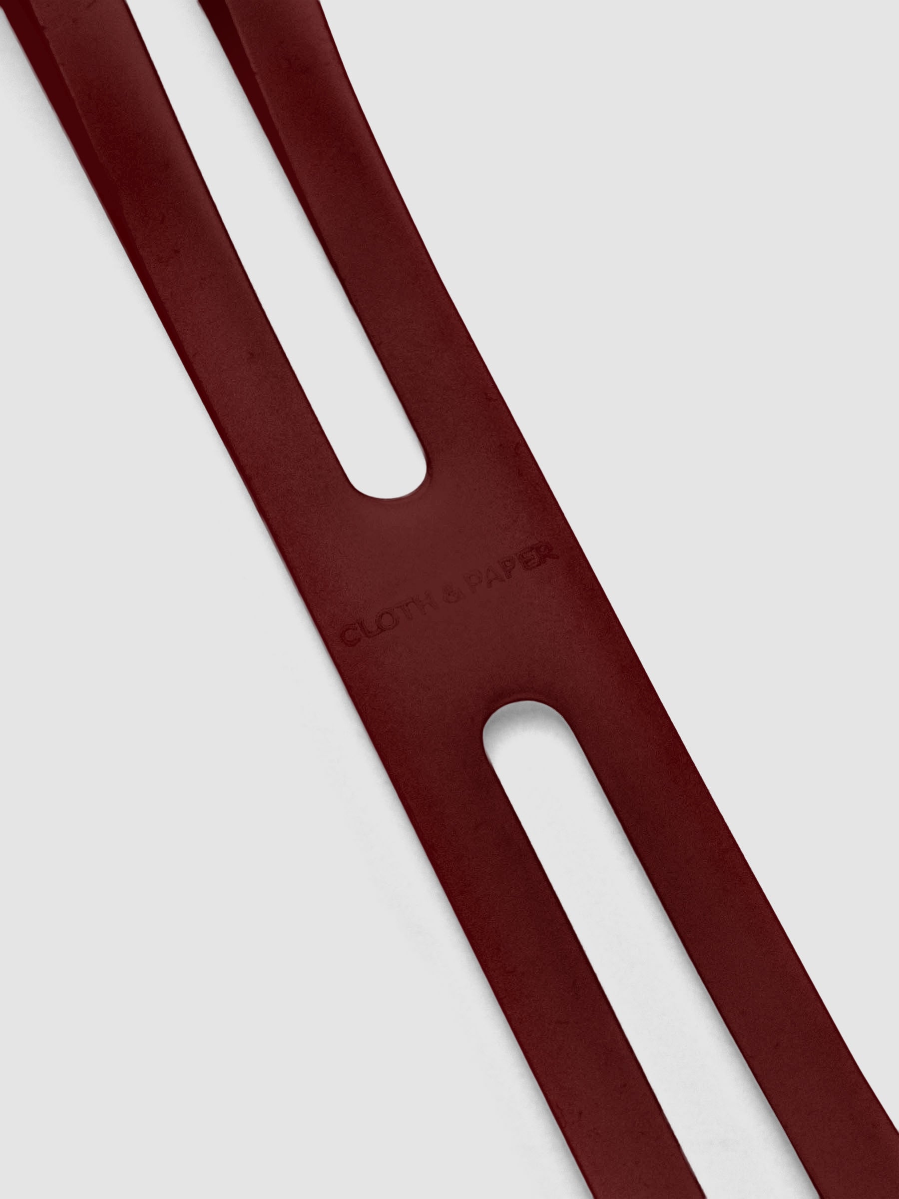 Close up of the debossed Cloth and Paper logo on the large bordeaux planner closure band.