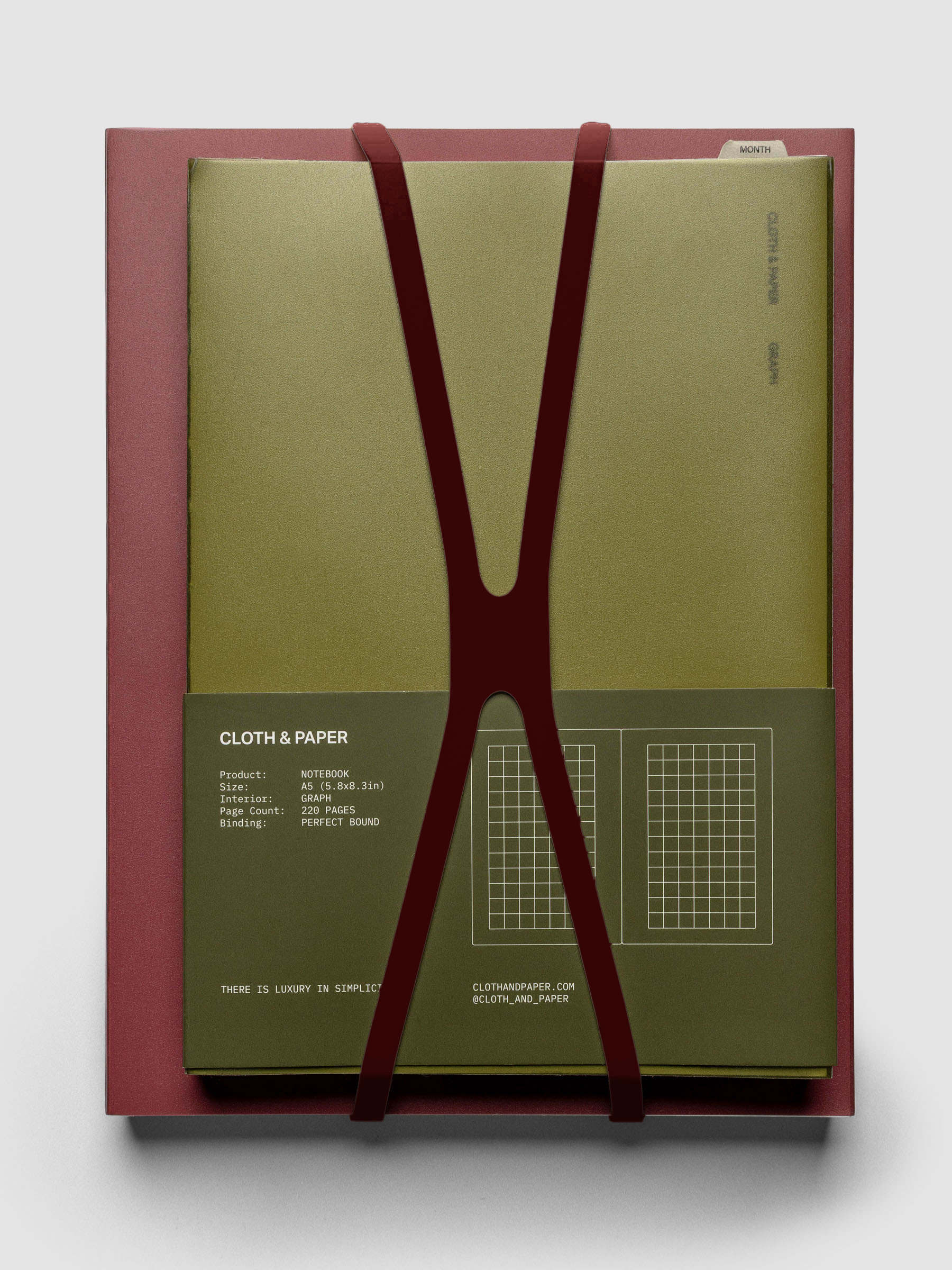 Large bordeaux planner closure band holding an A5 perfect bound notebook.