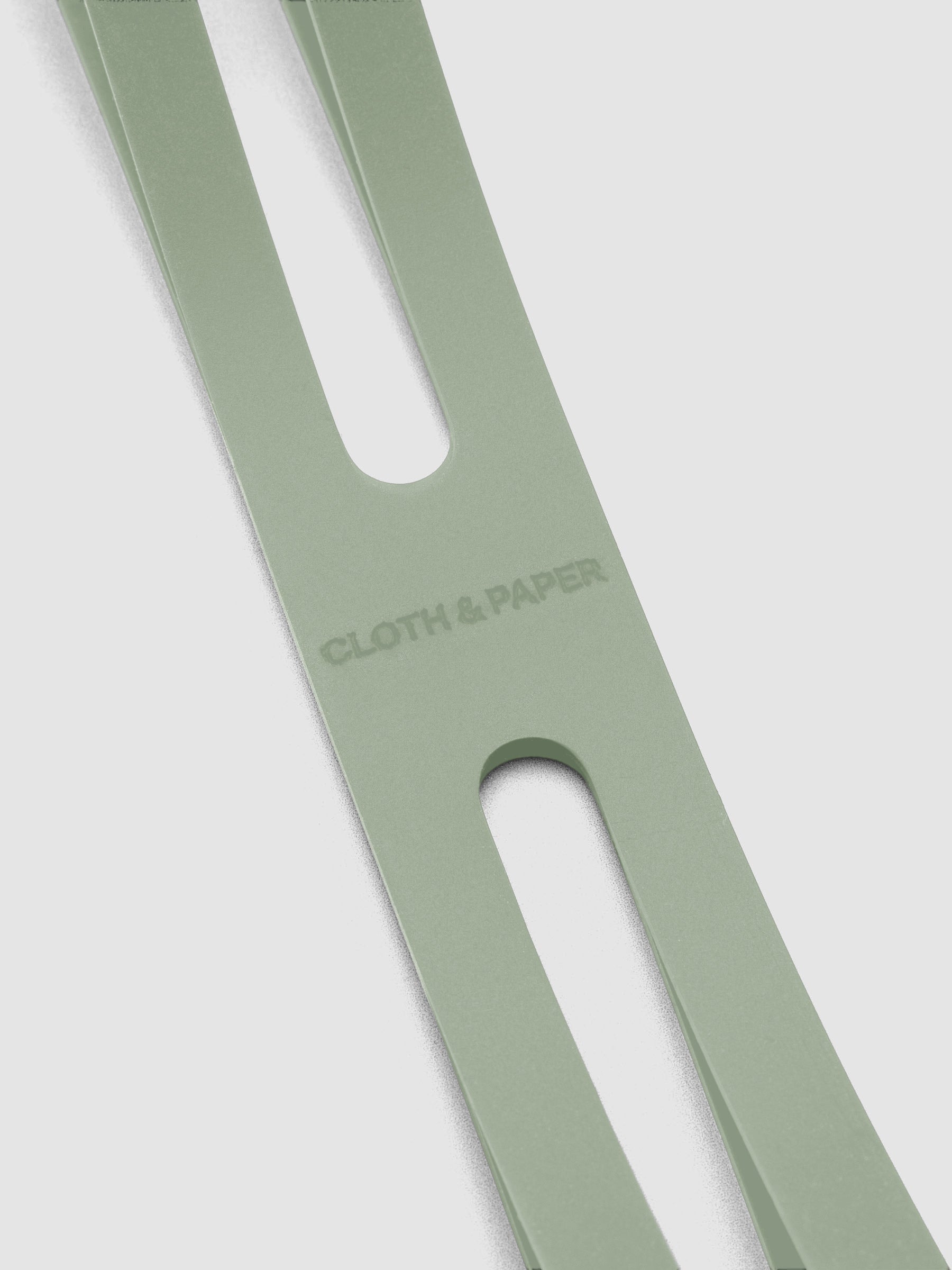 Close up of the debossed Cloth and Paper logo on the small matcha planner closure band.