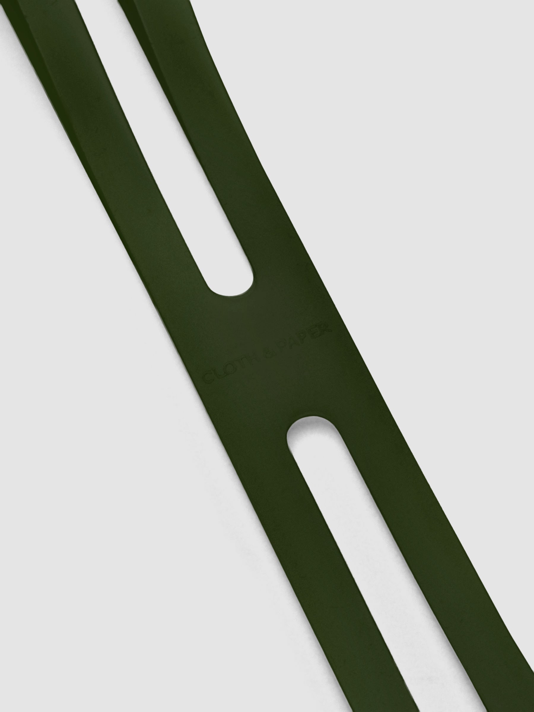 Close up of the debossed Cloth and Paper logo on the large olive planner closure band.