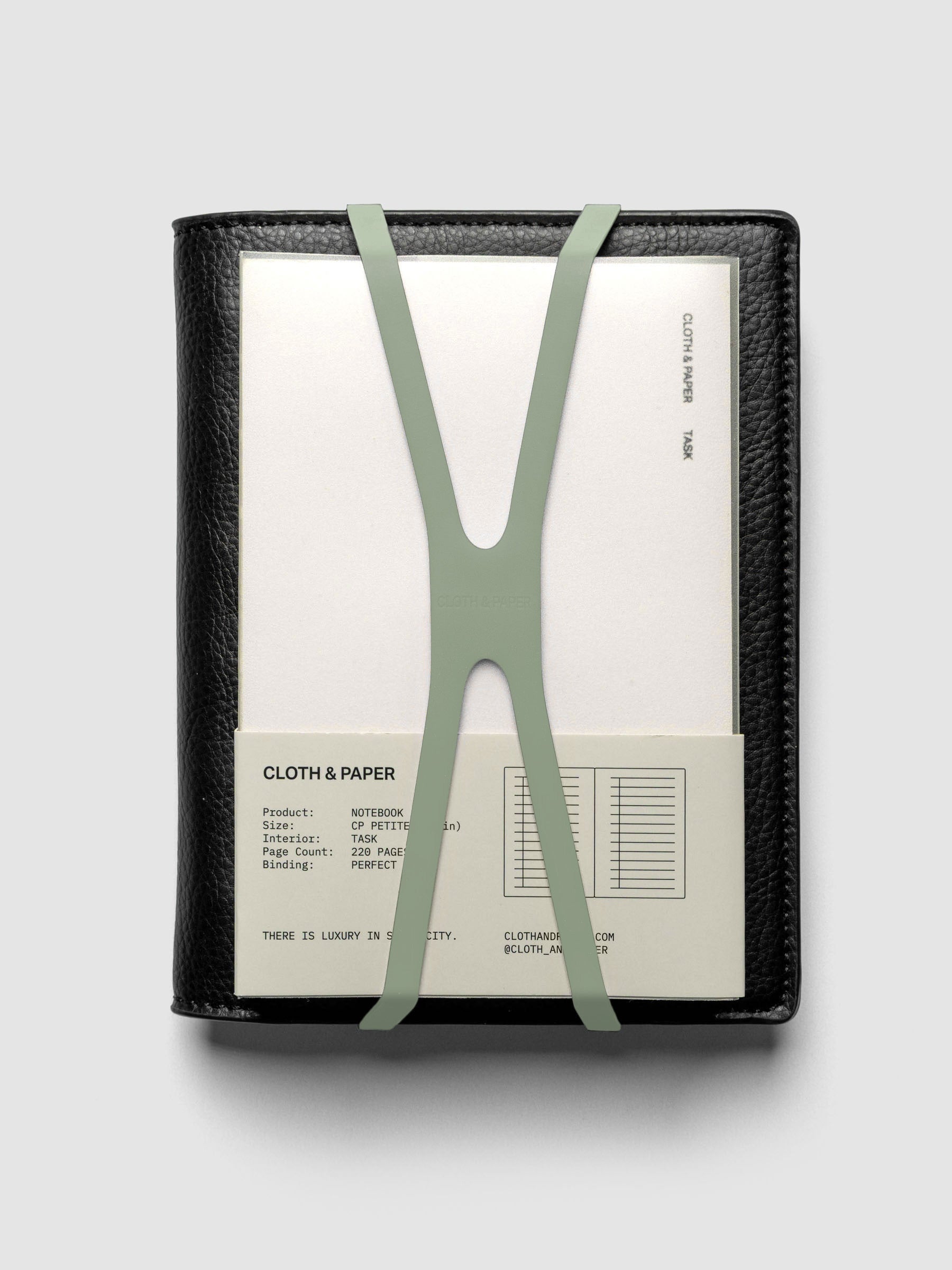 Small matcha planner closure band holding a CP Petite perfect bound notebook on a black leather folio.