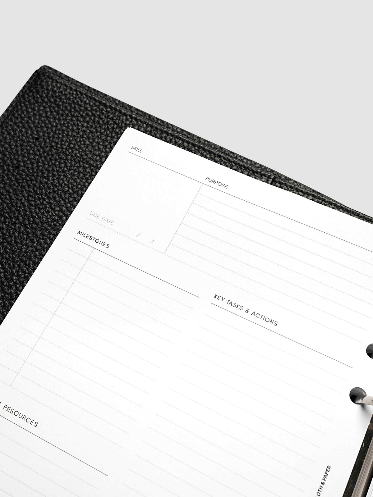 Close-up at an angle of the left page of a skill spread in the A5 6-Ring Punch Personal Curriculum Planner Inserts, showing the skill, purpose and due date fields above the milestones section