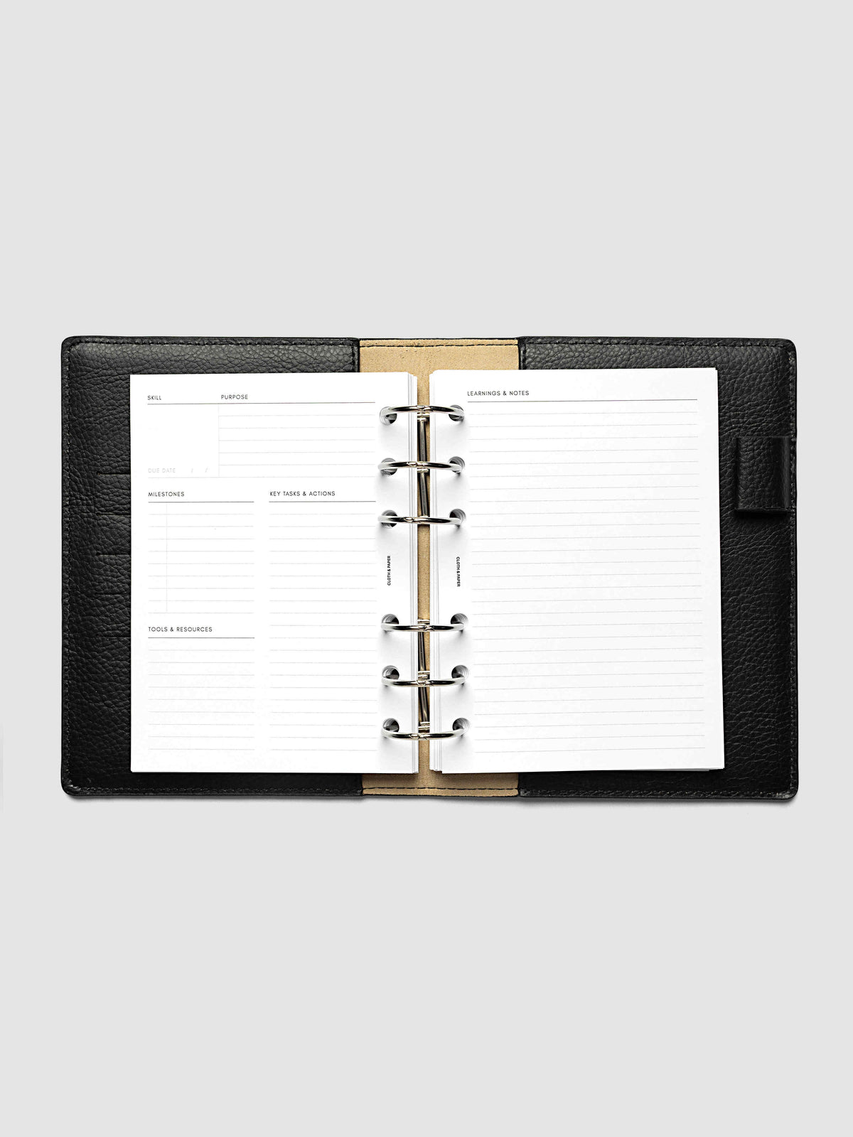The A6 Personal Curriculum Planner Inserts open in a black leather ring bound planner to a skill spread, with skill, purpose, milestones, key tasks and resources on the left and lined learnings and notes on the right