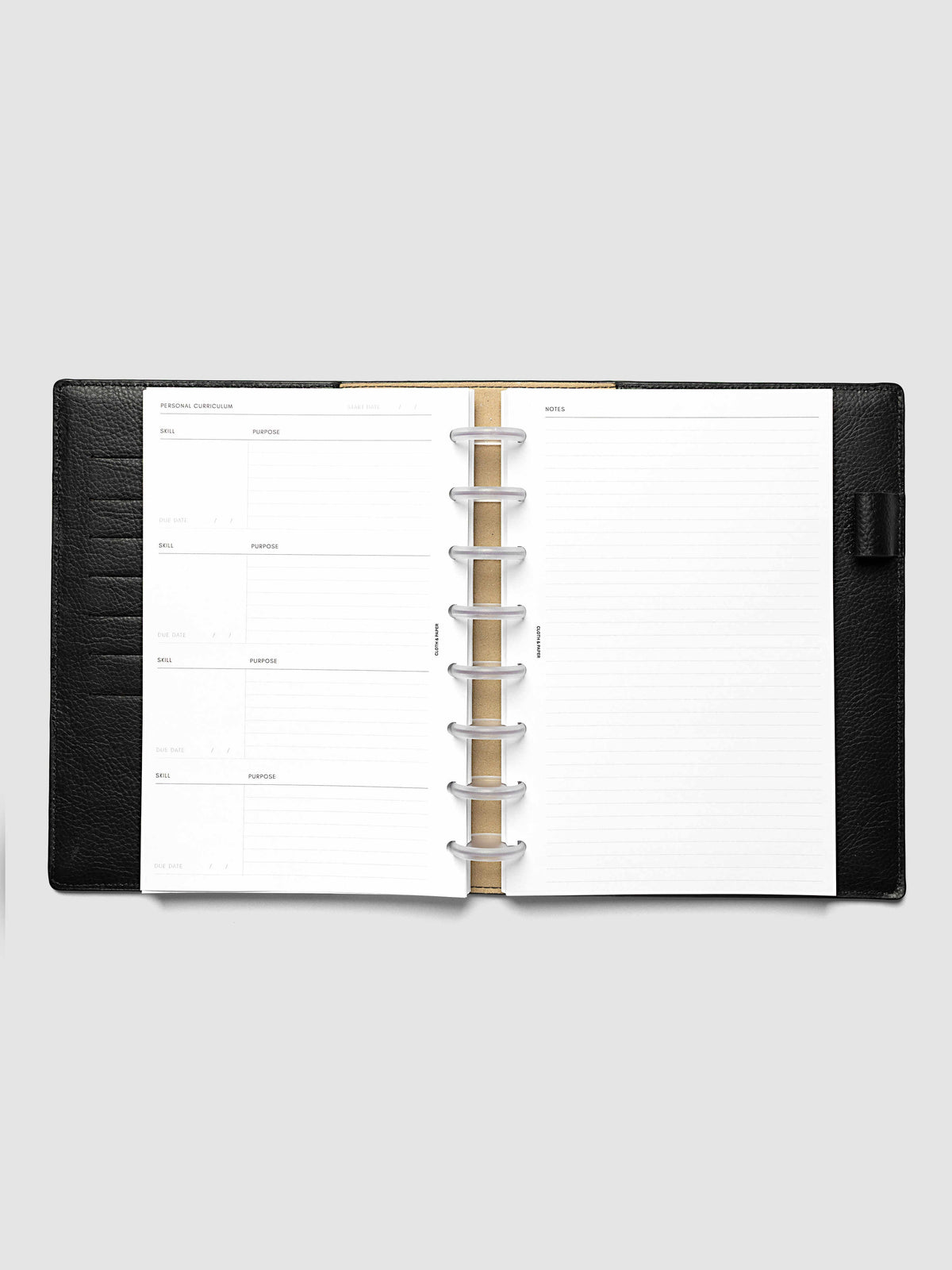The Half Letter 8-Disc Punch Personal Curriculum Planner Inserts open in a black leather ring bound planner to the index spread, four skill entries with purpose and due date on the left and a lined notes page on the right