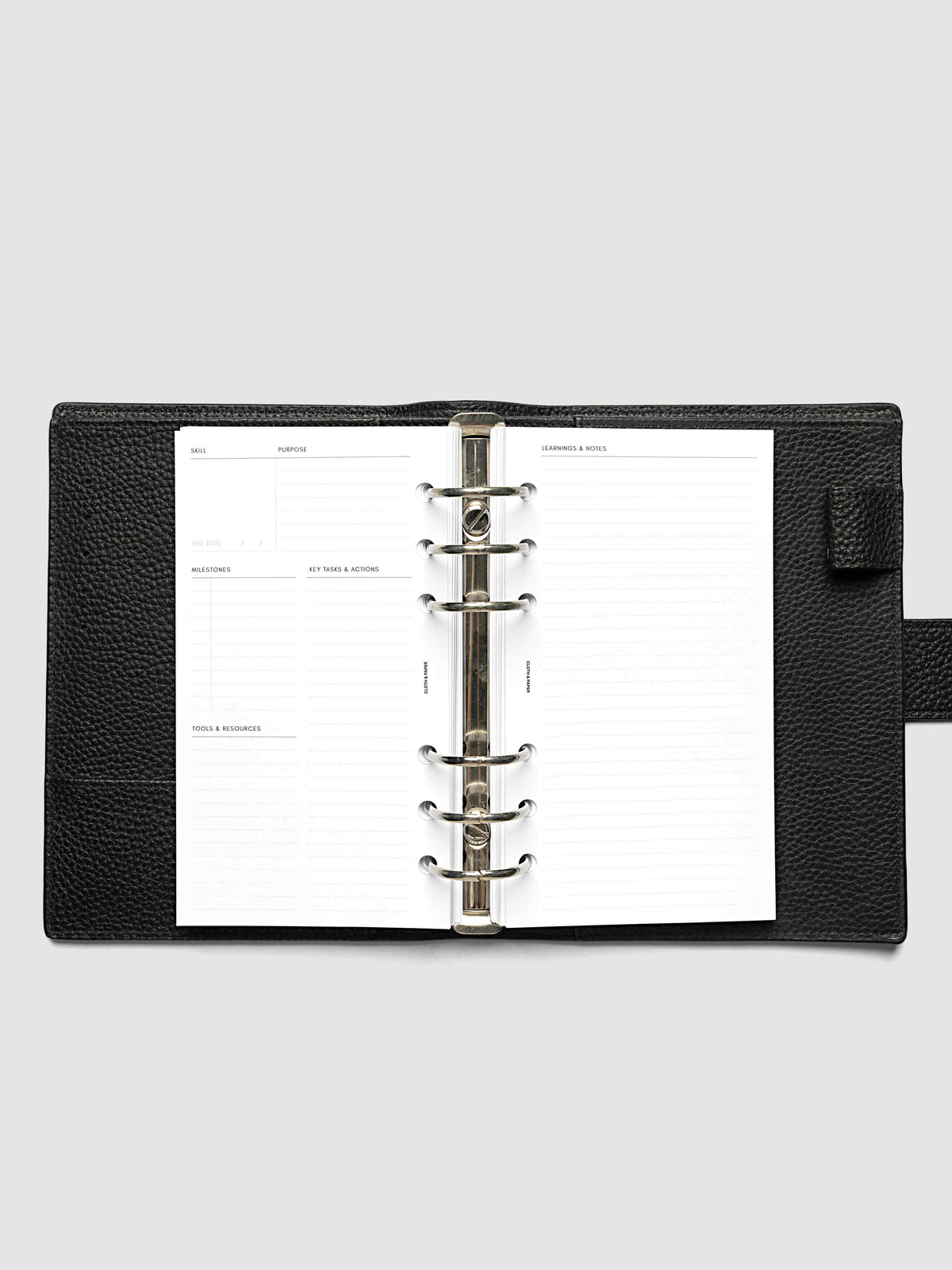 The Personal Personal Curriculum Planner Inserts open in a black leather ring bound planner to the index spread, four skill entries with purpose and due date on the left and a lined notes page on the right