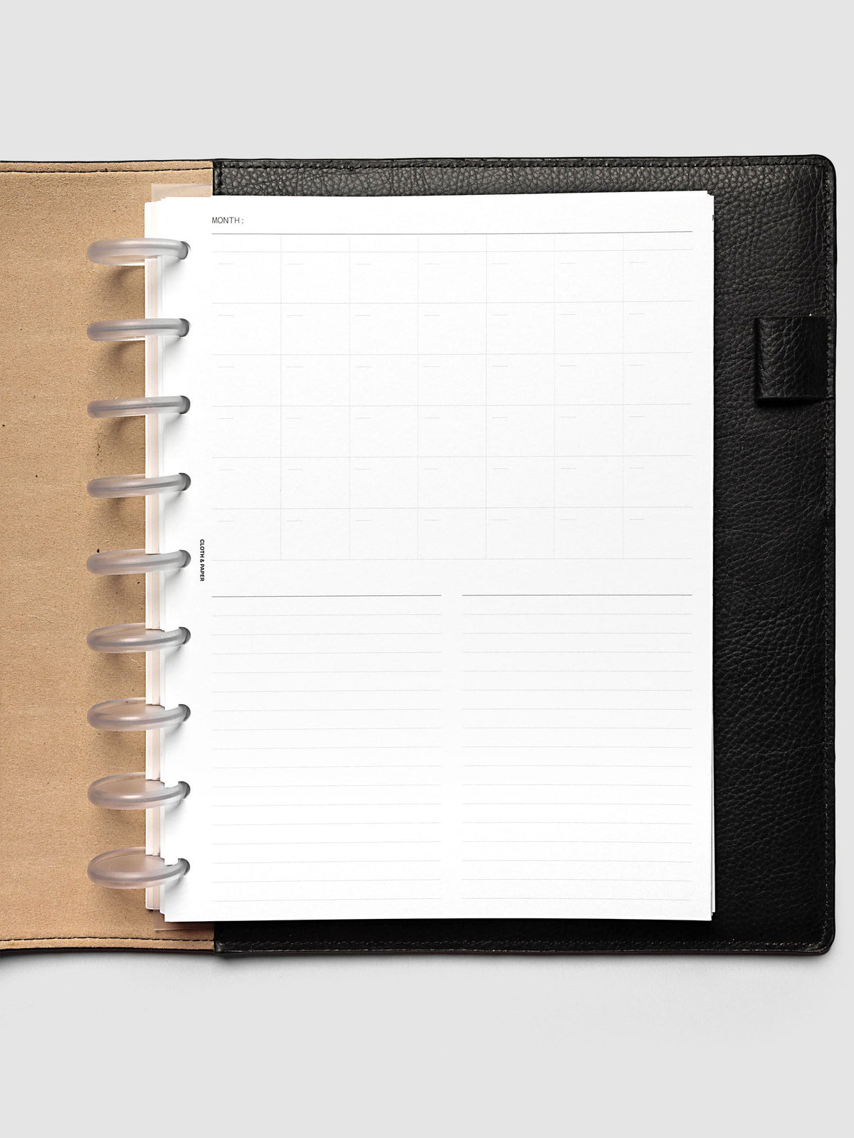 Monthly Fold Out Planner Insert Set of 2, HP Classic 9-Disc Punch, the blank insert folded closed in a black leather discbound planner with frosted clear discs and a kraft brown interior cover