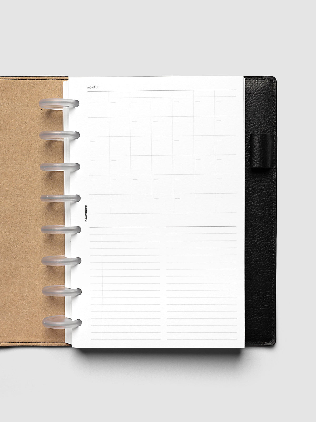 Monthly Fold Out Planner Insert Set of 2, Half Letter 8-Disc Punch, the insert folded closed in a black leather discbound planner with frosted clear discs and a kraft brown interior cover