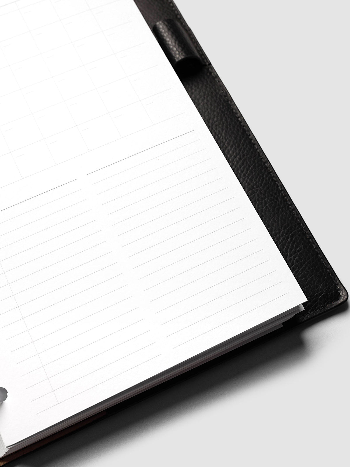 Monthly Fold Out Planner Insert Set of 2, Half Letter 8-Disc Punch, close-up of the two lined note columns filling the lower half of the page, black pebbled leather cover and pen loop along the right