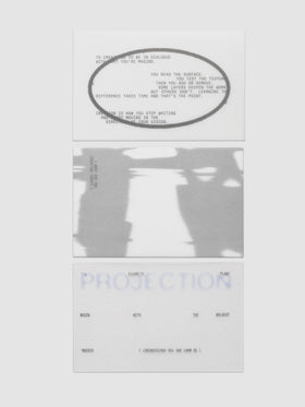 Projection Journaling Card Set, three cards stacked in a column on a light gray background, one white with gray type inside a wide gray oval, one covered edge to edge in a blurred gray and white image, one pale gray with soft blue lettering behind scattered black type