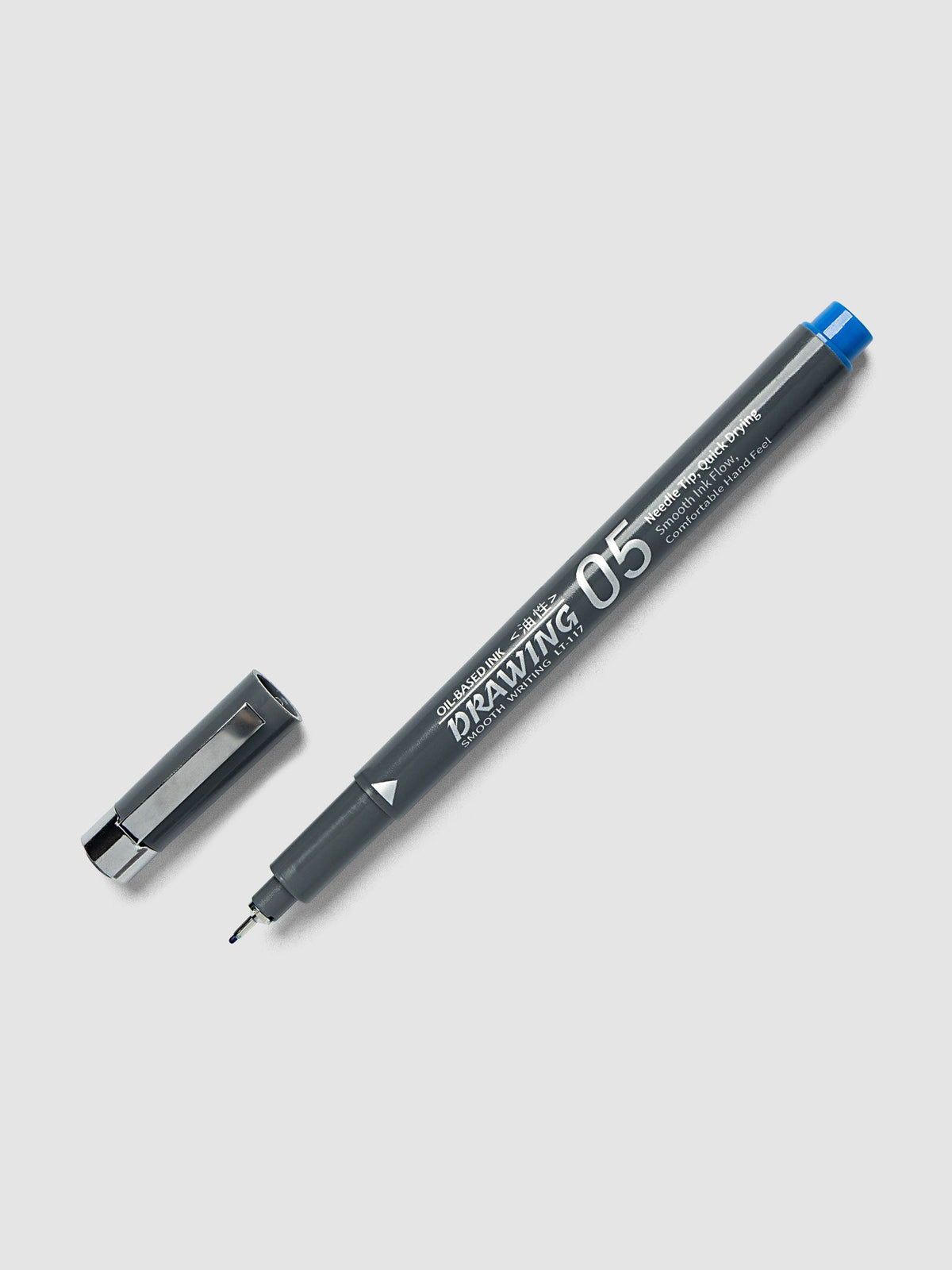 Leto Drawing Oil-Based Ink Pen, Blue | 0.5 mm, uncapped pen angled across a light gray background with its cap set to the left, gray barrel printed in silver, a blue end cap and a fine exposed needle tip