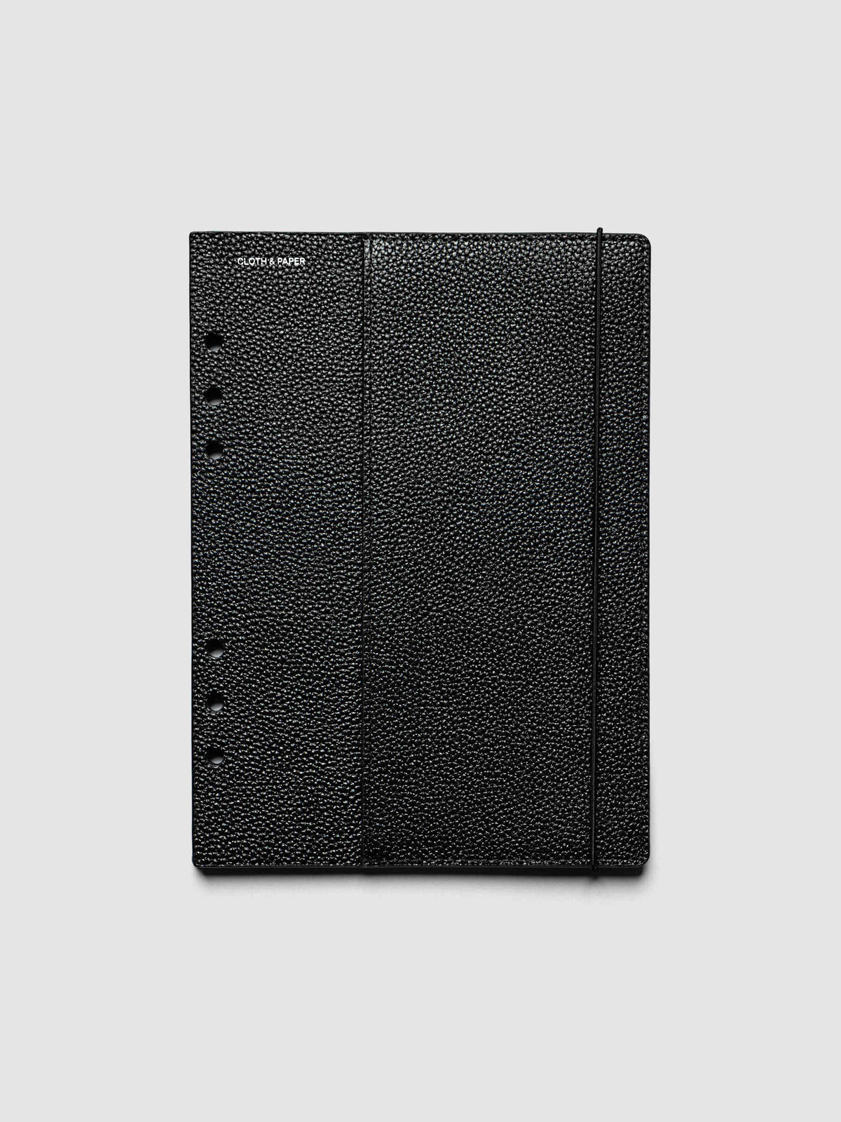 The front cover of the A5 6-Ring Punch Genuine Leather Planner Cover Set laid flat, showing pebbled black leather, the silver foiled logo at the top left, the punch holes down the left edge, and the bungee cord running down the right
