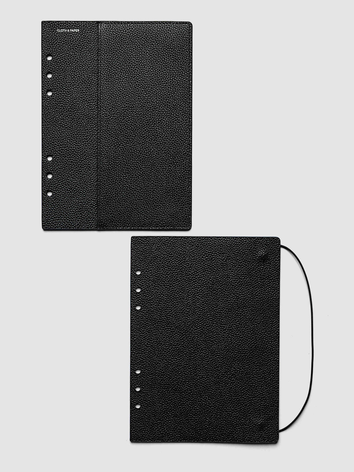 Both covers of the A5 6-Ring Punch Genuine Leather Planner Cover Set laid flat side by side, the front cover with its sewn pocket seam and the back cover with the bungee cord looping out from the edge