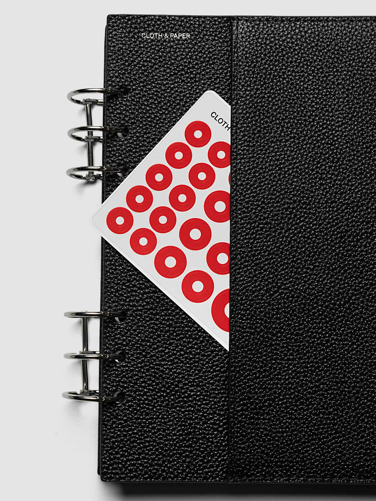 A red dot sticker sheet slipped into the vertical sewn pocket on the face of the front cover of the A5 6-Ring Punch Genuine Leather Planner Cover Set