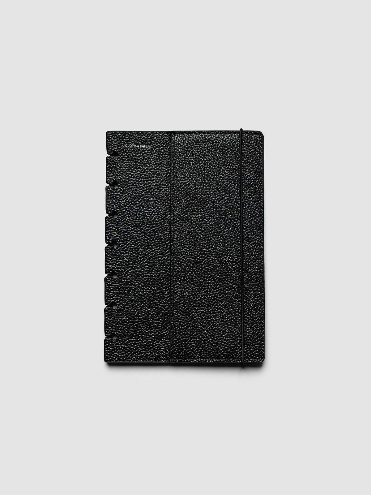 The front cover of the HP Mini Genuine Leather Planner Cover Set laid flat, showing pebbled black leather, the silver foiled logo at the top left, the punch holes down the left edge, and the bungee cord running down the right