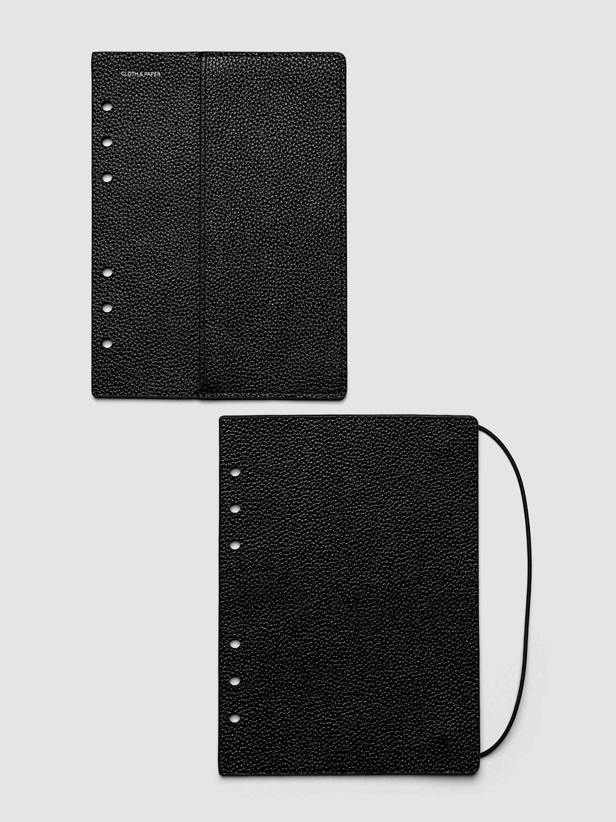 The Personal Wide Genuine Leather Planner Cover Set closed on a ring bound planner, showing the silver rings, the silver foiled logo, and the bungee cord holding the stack shut