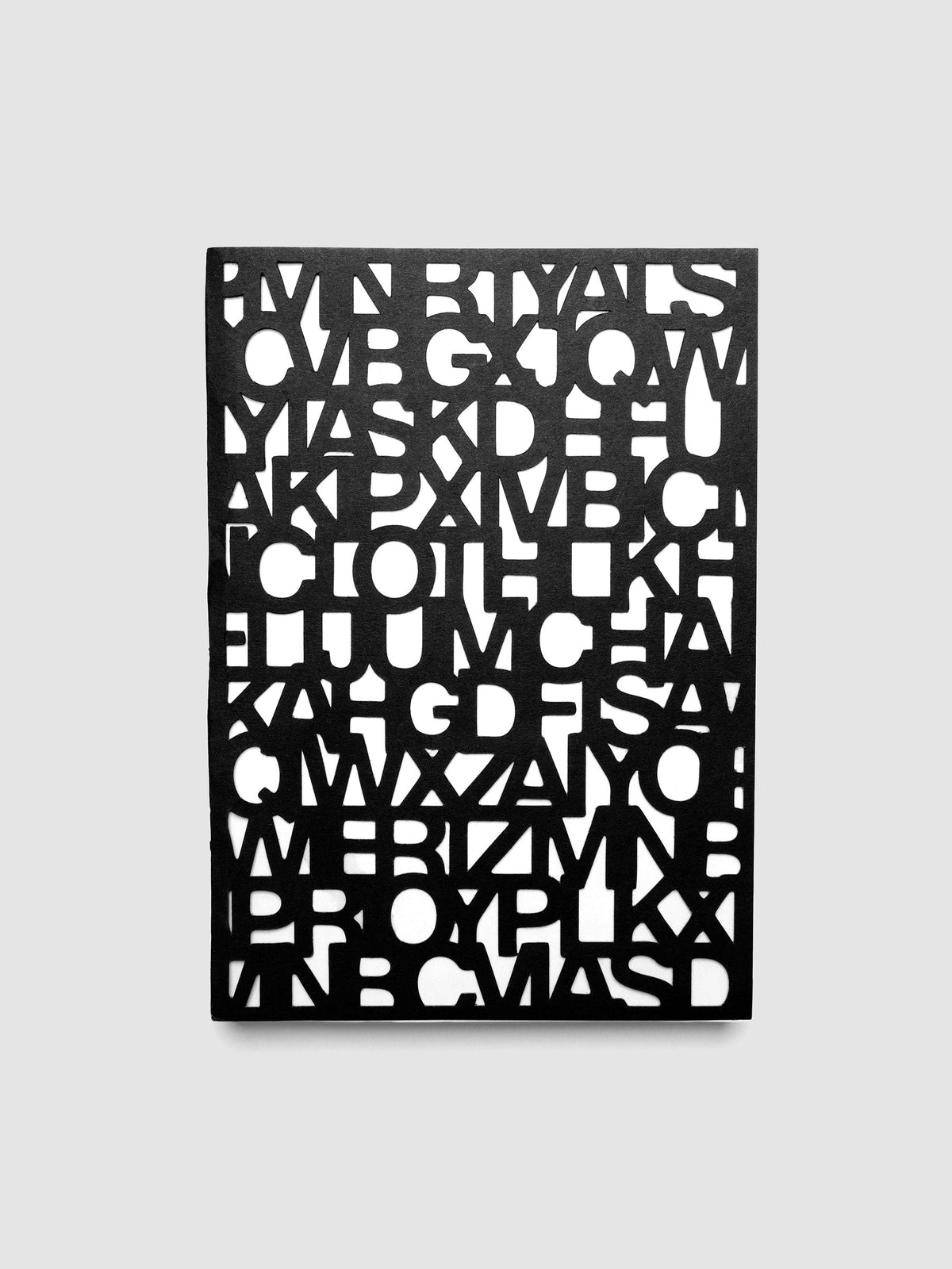 The Precision Notebook | A5 closed, showing the cover cut all the way through in the Precision letter pattern over a light layer beneath
