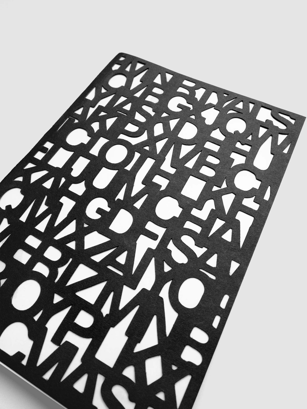 The Precision Notebook | A5 at an angle, showing the depth of the cut letters where the top cover layer lifts away from the book