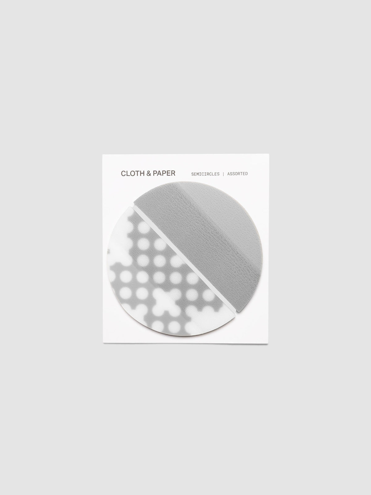Both designs of the Transparent Semicircle Sticky Notes on their backer card, one solid Ash half circle and one in the Punched Holes pattern meeting to form a full circle
