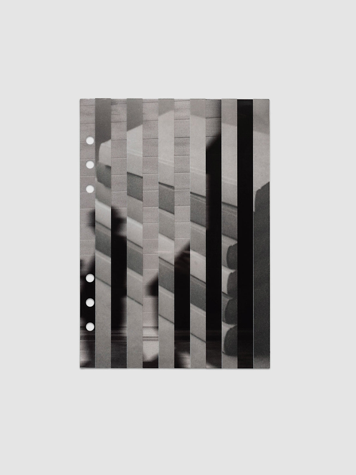 The vellum base layer of the A5 6-Ring Punch Strips Planner Dashboard Duo laid flat, showing a greyscale photograph of a stack of books sliced into vertical strips and offset