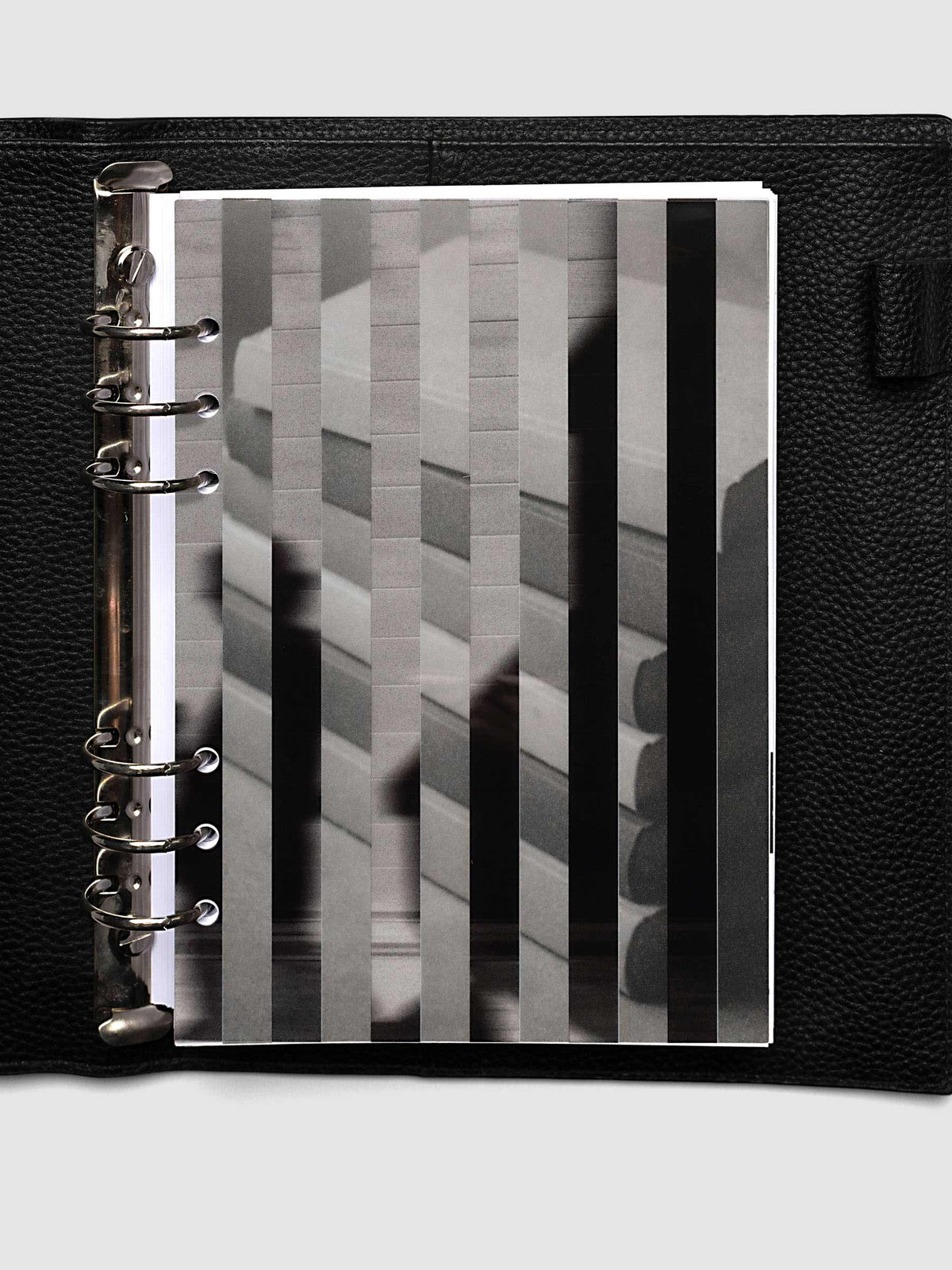 The A5 6-Ring Punch Strips Planner Dashboard Duo layered at the front of a black leather ring bound planner, both images combining into one striped picture