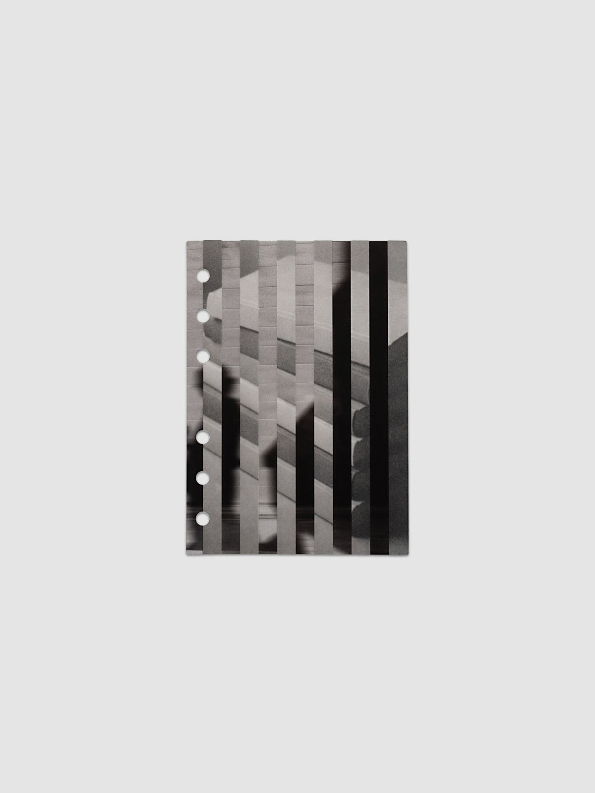 The vellum base layer of the A6 Strips Planner Dashboard Duo laid flat, showing a greyscale photograph of a stack of books sliced into vertical strips and offset
