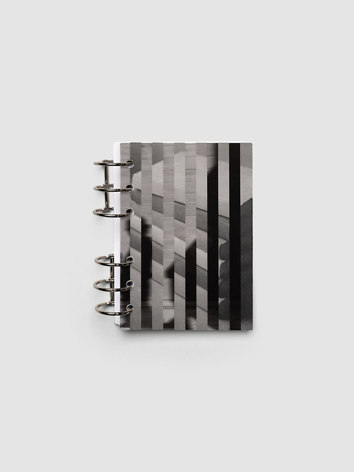 Both layers of the A6 Strips Planner Dashboard Duo overlapping, the clear plastic top layer of silhouettes in motion set across the vellum base layer of stacked books