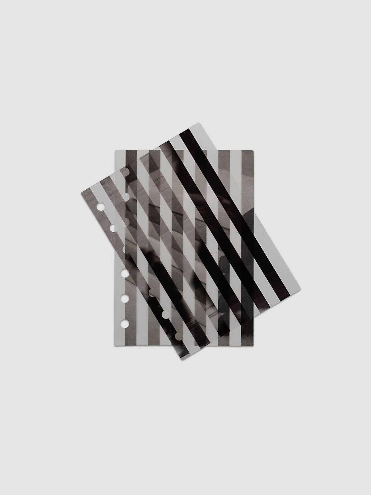 The A6 Strips Planner Dashboard Duo layered at the front of a black leather ring bound planner, both images combining into one striped picture
