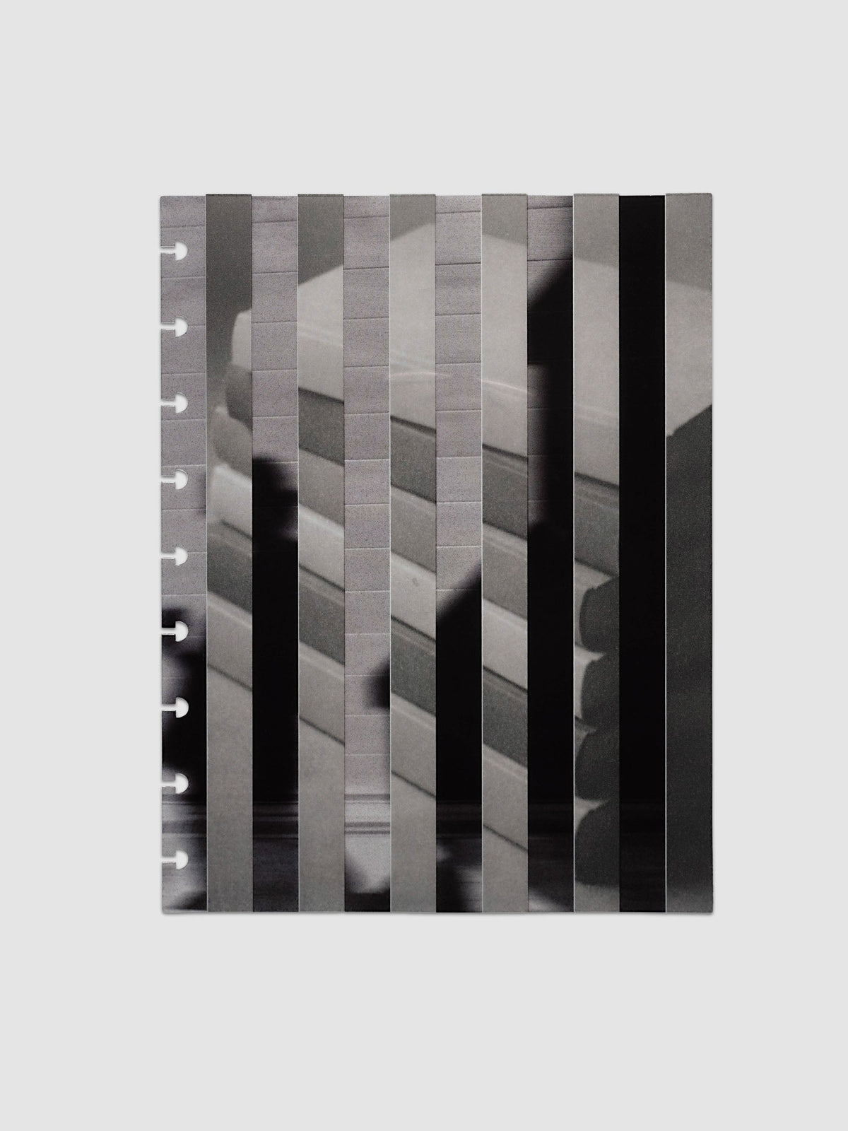 The vellum base layer of the HP Classic 9-Disc Punch Strips Planner Dashboard Duo laid flat, showing a greyscale photograph of a stack of books sliced into vertical strips and offset