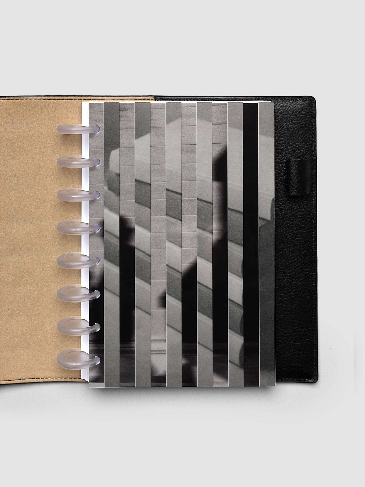 The Half Letter 8-Disc Punch Strips Planner Dashboard Duo layered at the front of a black leather ring bound planner, both images combining into one striped picture