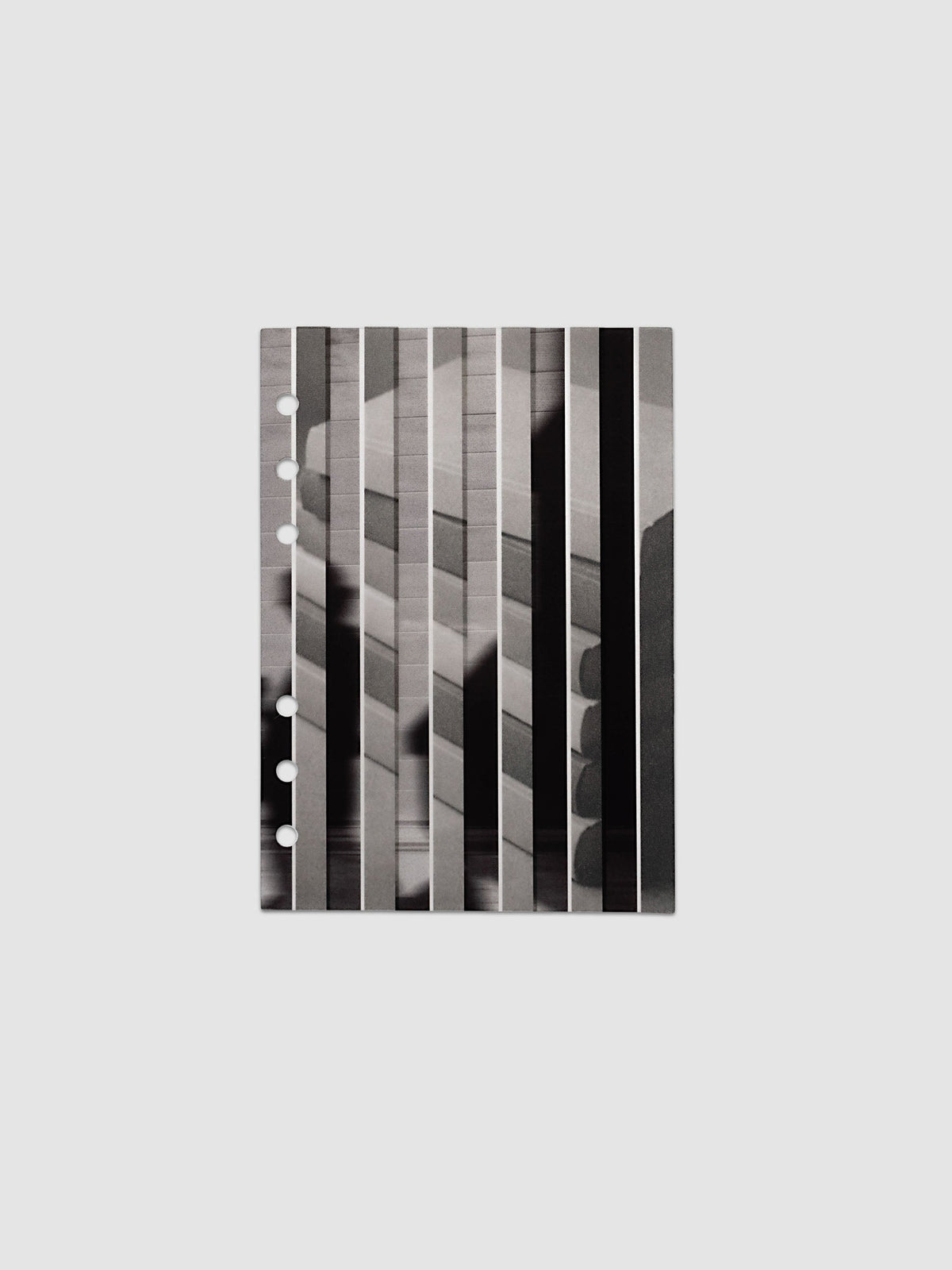 The vellum base layer of the Personal Wide Strips Planner Dashboard Duo laid flat, showing a greyscale photograph of a stack of books sliced into vertical strips and offset