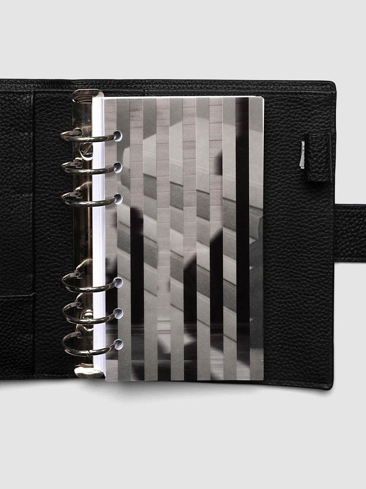The Personal Strips Planner Dashboard Duo layered at the front of a black leather ring bound planner, both images combining into one striped picture