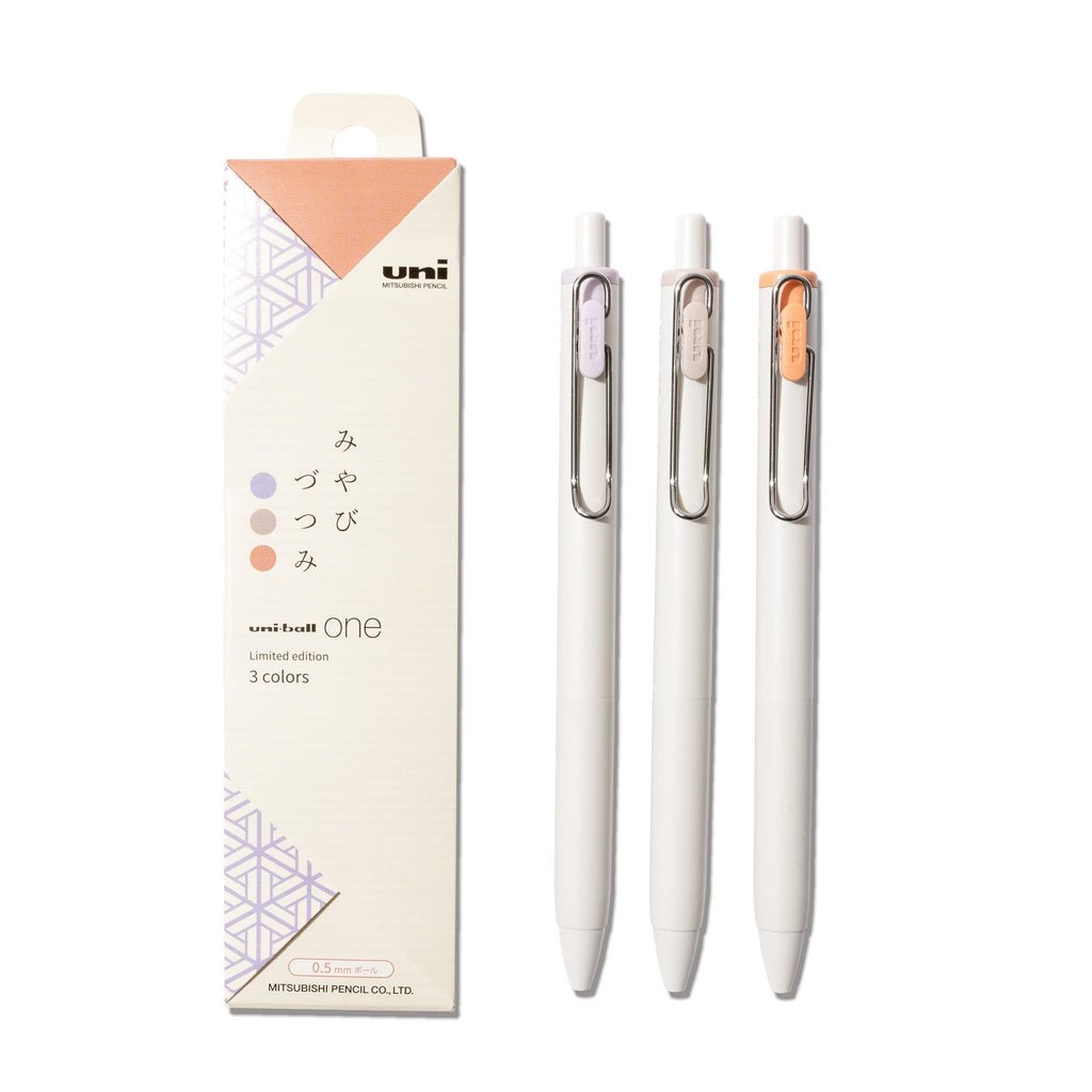 Set of three pens - purple, brown, and orange - displayed next to their packaging on a white background.
