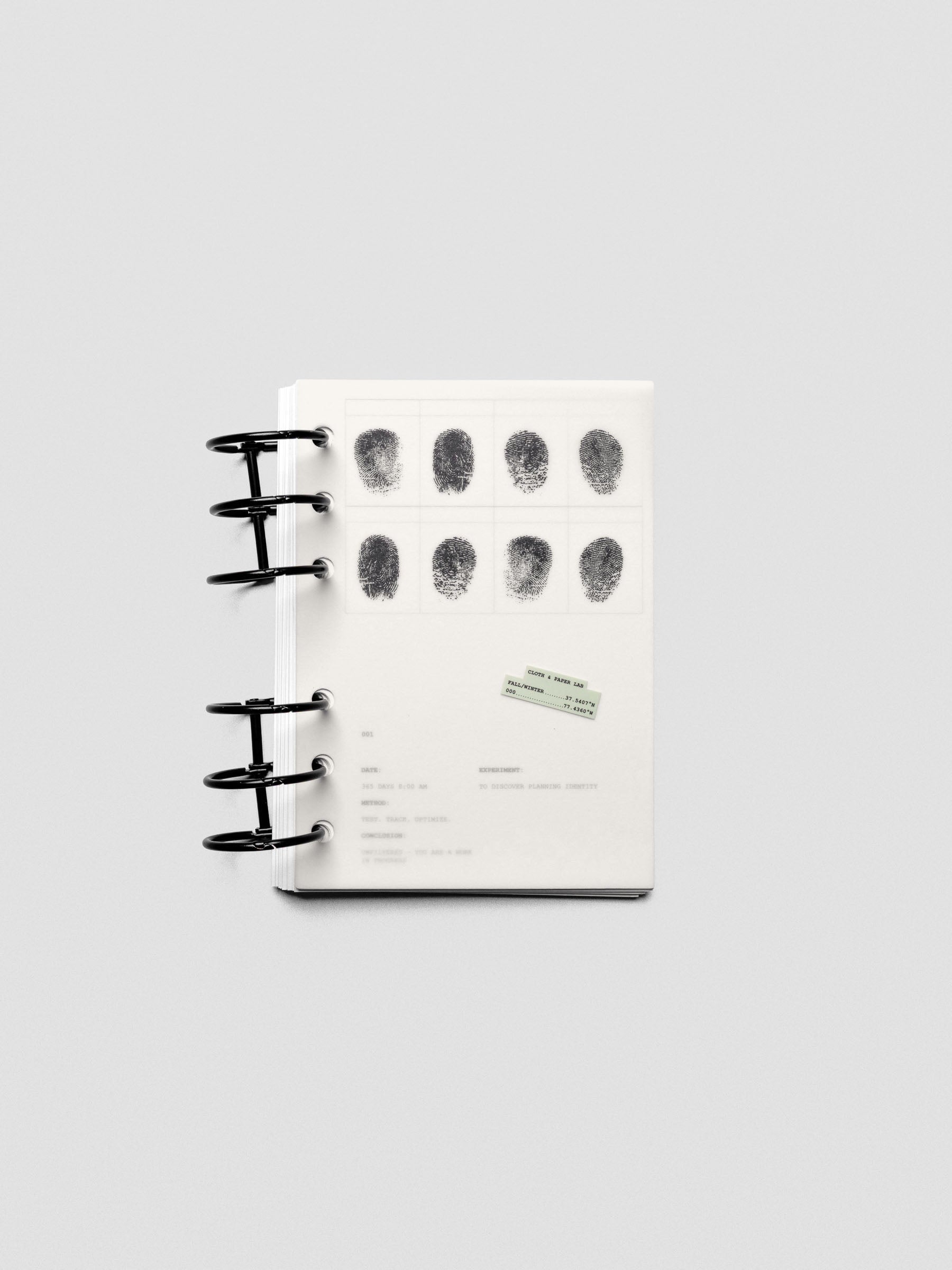 Two layered A6 sized planner dashboards, one semi-transparent, one matte, featuring a fingerprint design shown in a ring bound planner.